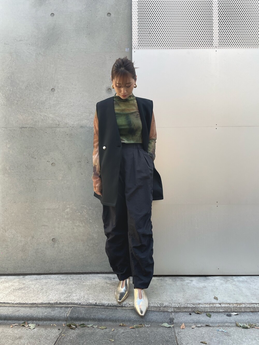 ブラック系のベスト、ブラック系のその他パンツ、グリーン系のTシャツ/カットソーを着用したレディースの春コーディネートの2枚目の写真