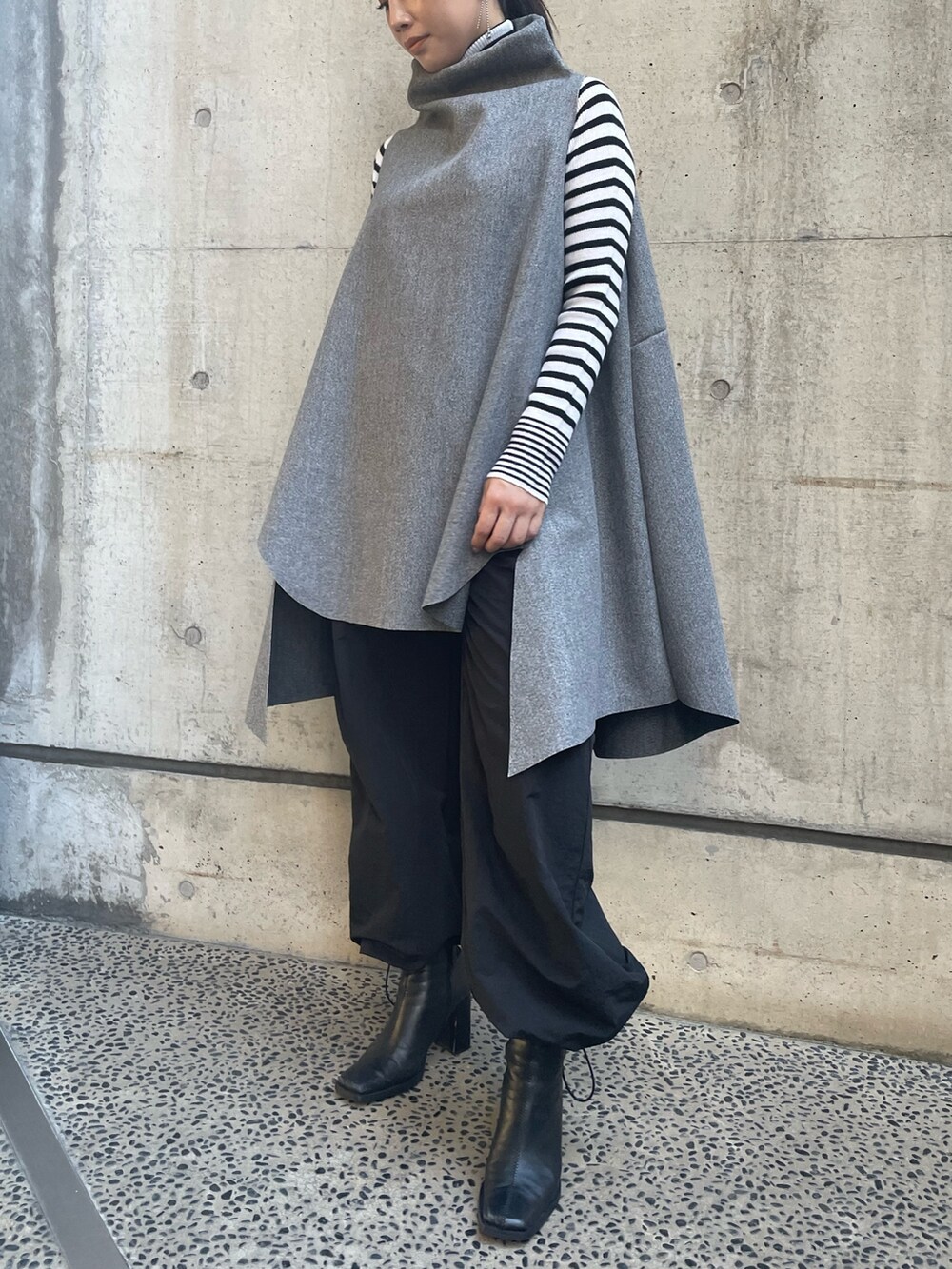 グレー系のベスト、ホワイト系のニット/セーターを着用したレディースの秋コーディネートの6枚目の写真