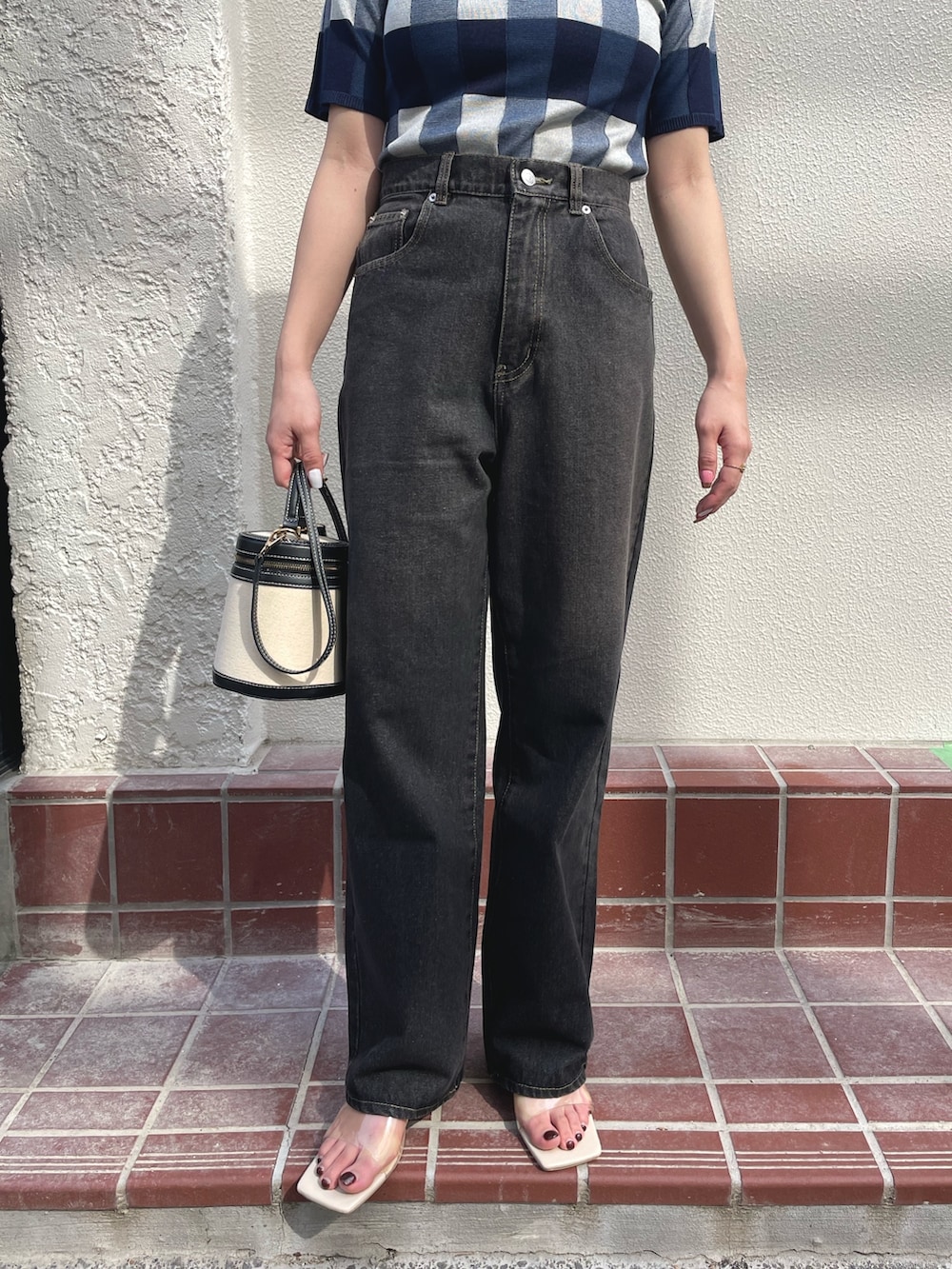 ブルー系のTシャツ/カットソー、ベージュ系のショルダーバッグ、ブラック系のデニムパンツを着用したレディースの春コーディネートの3枚目の写真