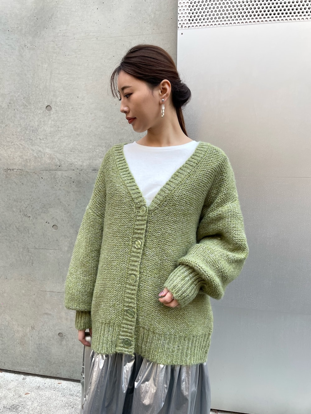 シルバー系のスカート、ホワイト系のスニーカー、ホワイト系のTシャツ/カットソーを着用したレディースの冬コーディネートの3枚目の写真