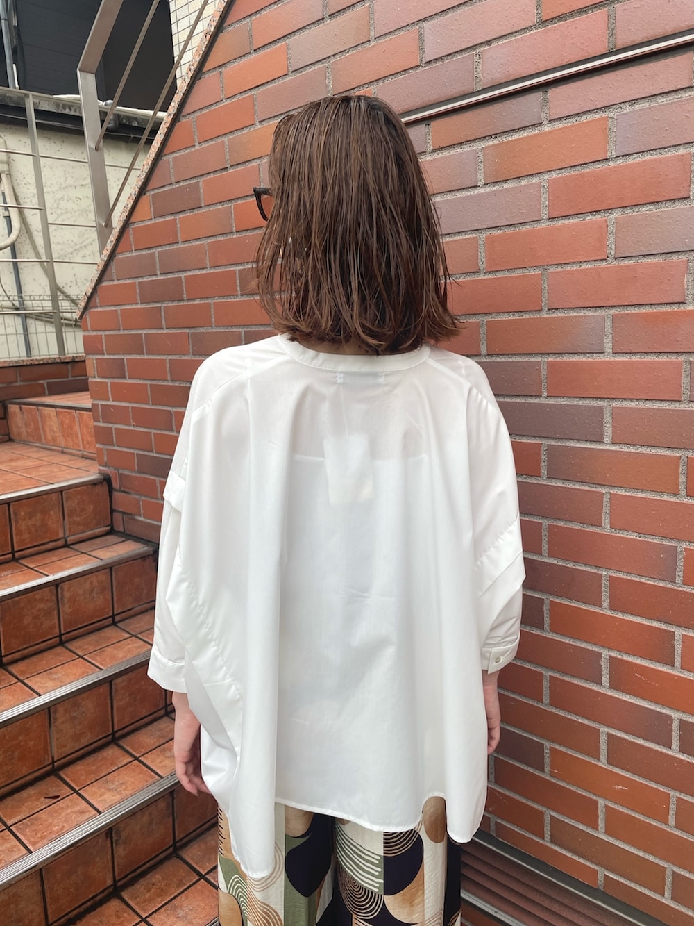 ブラウン系のその他パンツ、ホワイト系のシャツ/ブラウス、ブラック系のサングラスを着用したレディースの春コーディネートの4枚目の写真