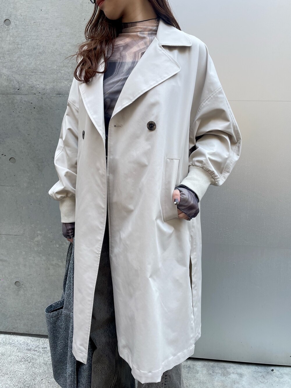 ベージュ系のトレンチコート、ブラック系のデニムパンツ、ホワイト系のスニーカーを着用したレディースの春コーディネートの5枚目の写真