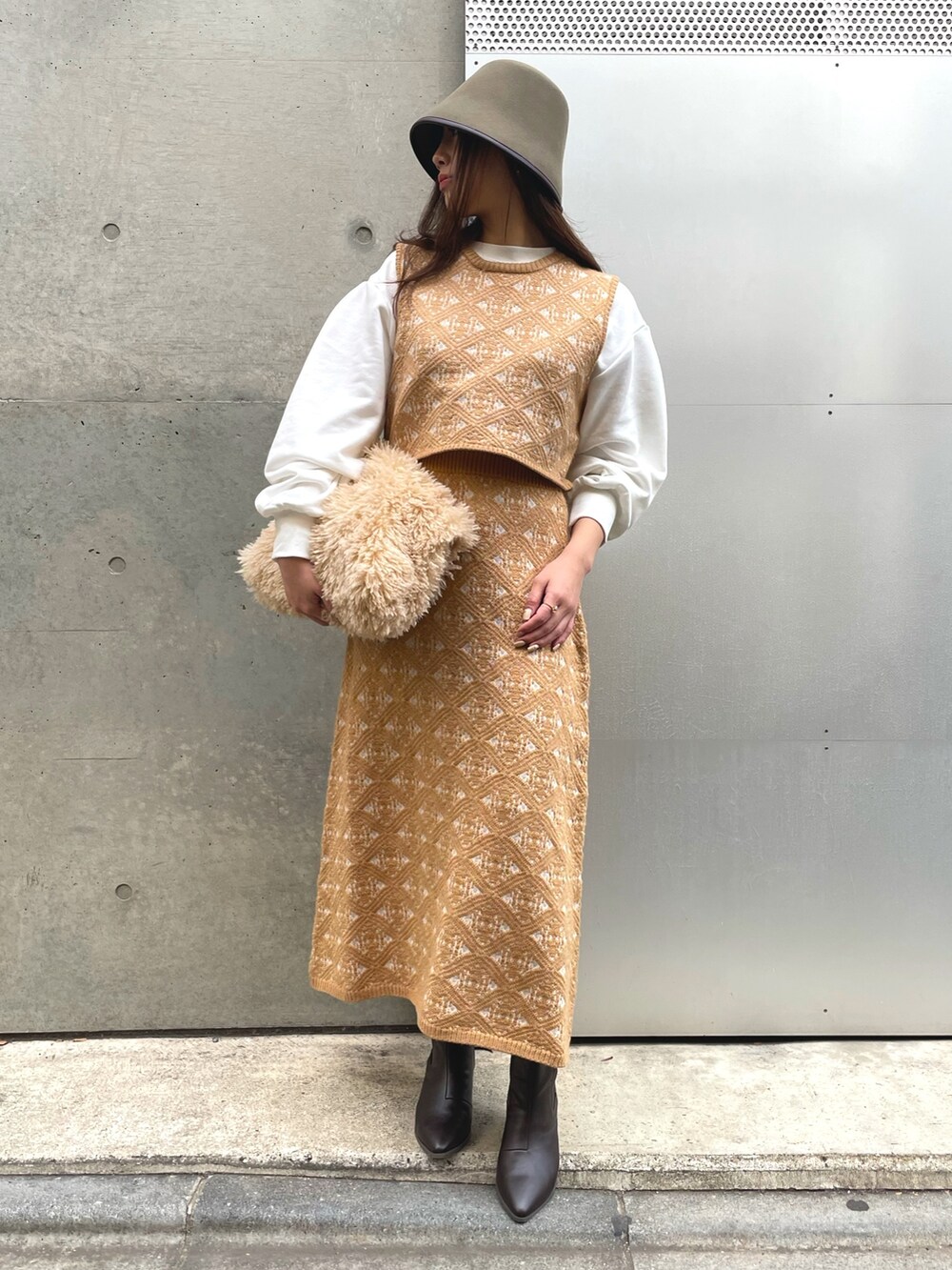 ベージュ系のトートバッグ、ベージュ系のスカート、グリーン系のハットを着用したレディースの冬コーディネートの4枚目の写真