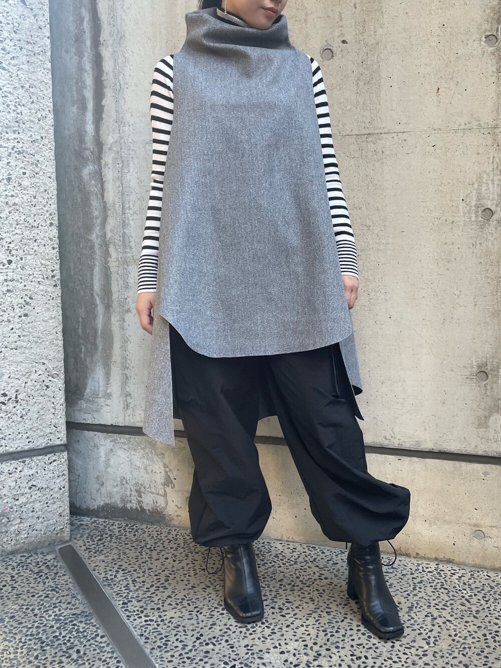 グレー系のベスト、ホワイト系のニット/セーターを着用したレディースの秋コーディネートの5枚目の写真