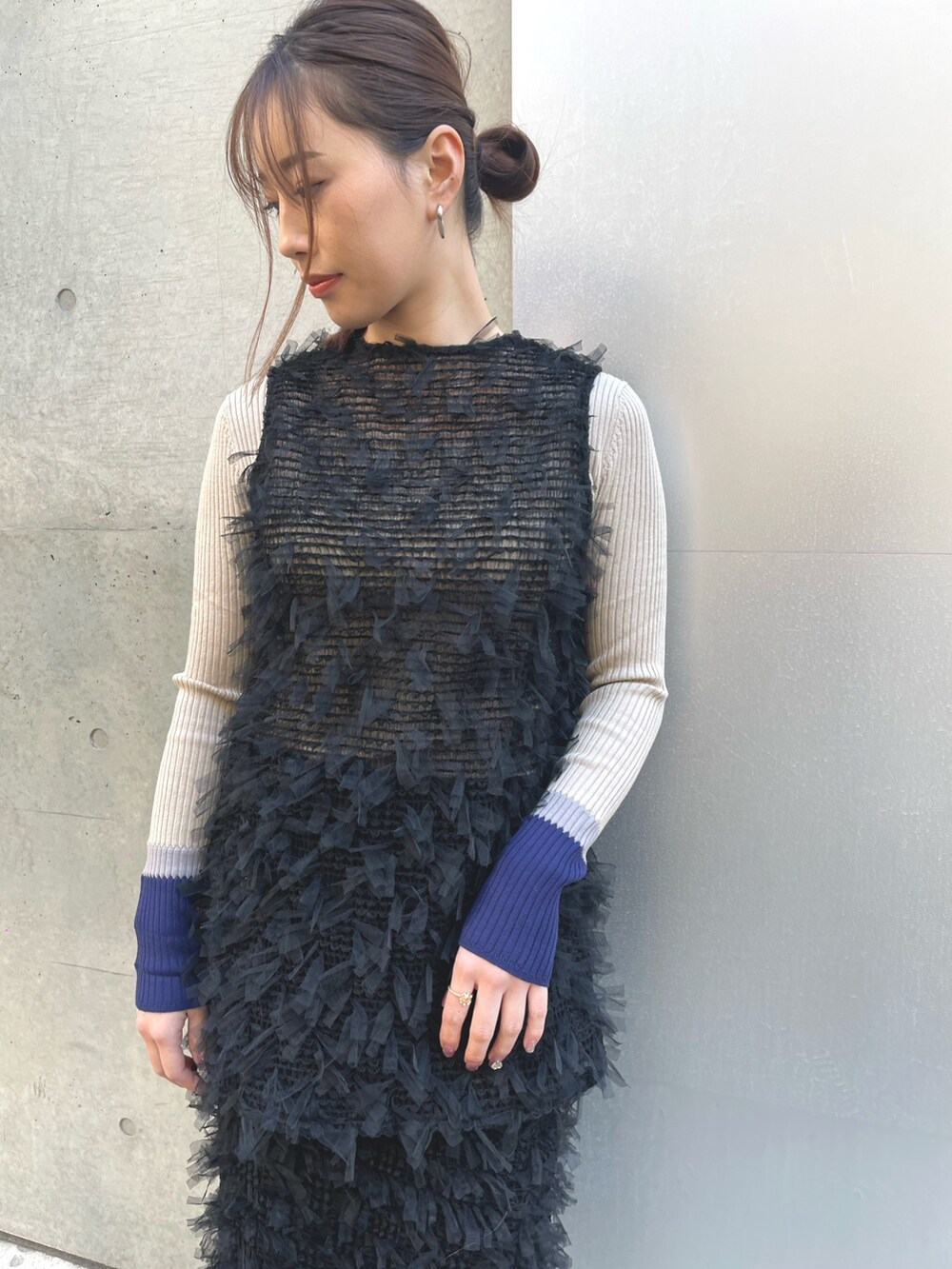 ベージュ系のニット/セーター、ブラック系のベスト、ブラック系のスカートを着用したレディースの冬コーディネートの3枚目の写真