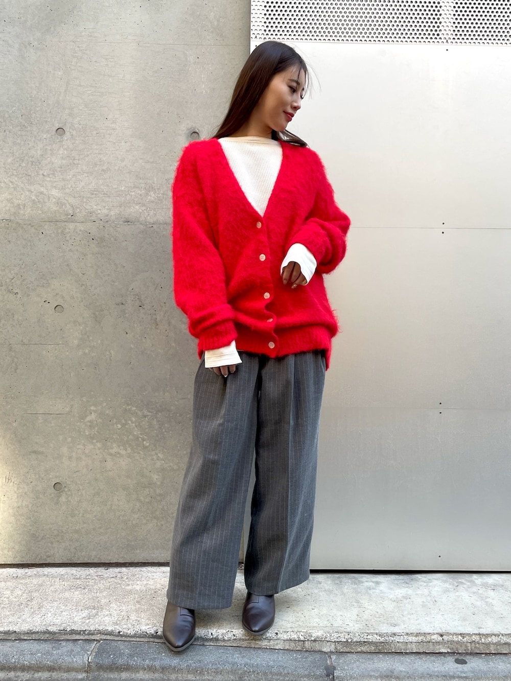 グレー系のその他パンツ、レッド系のカーディガン/ボレロを着用したレディースの冬コーディネートの2枚目の写真