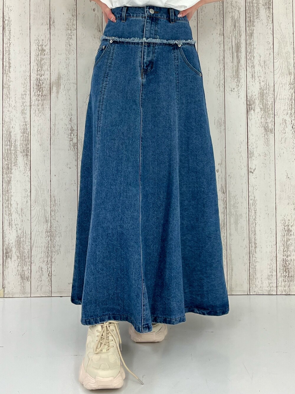 ブルー系のスカート、ベージュ系のスニーカーを着用したレディースの春コーディネートの3枚目の写真