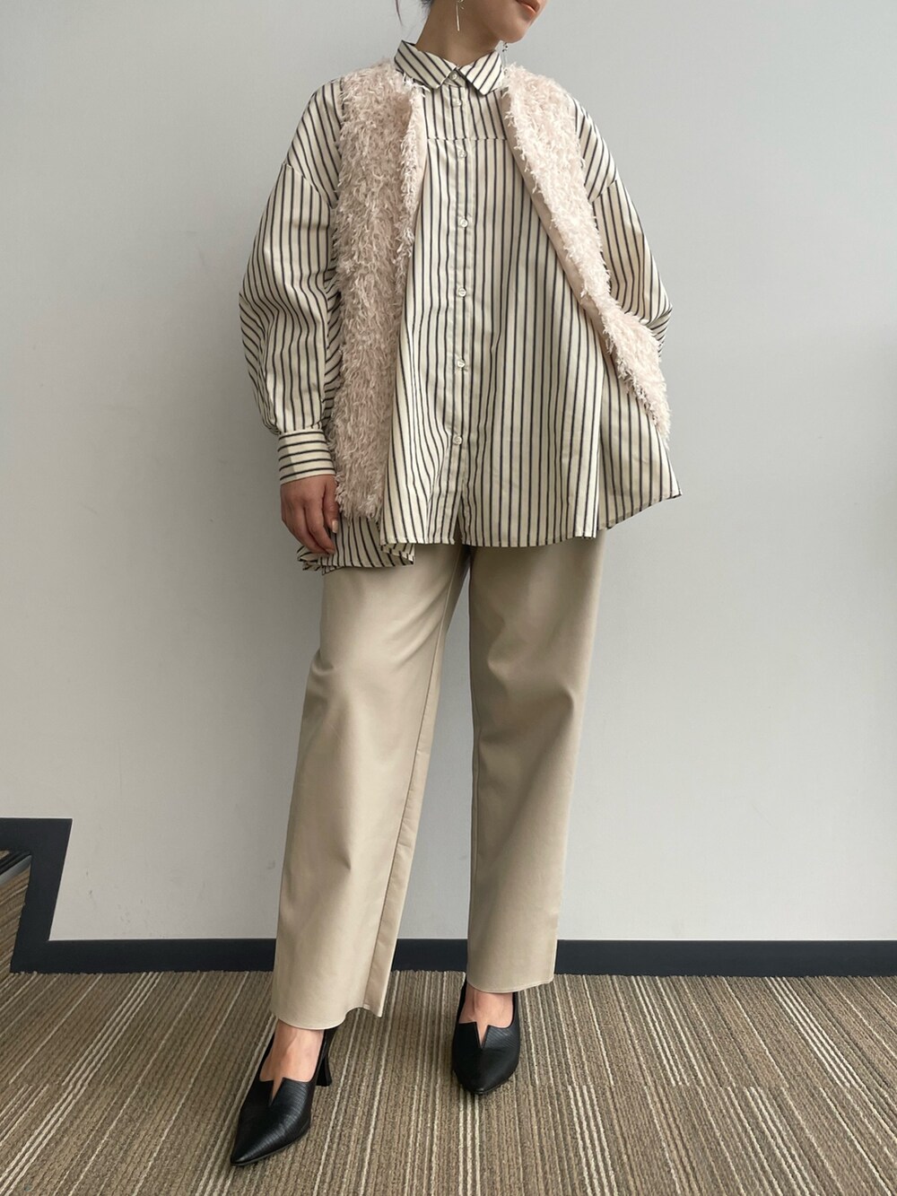 ベージュ系のベストを着用したレディースの冬コーディネートの6枚目の写真