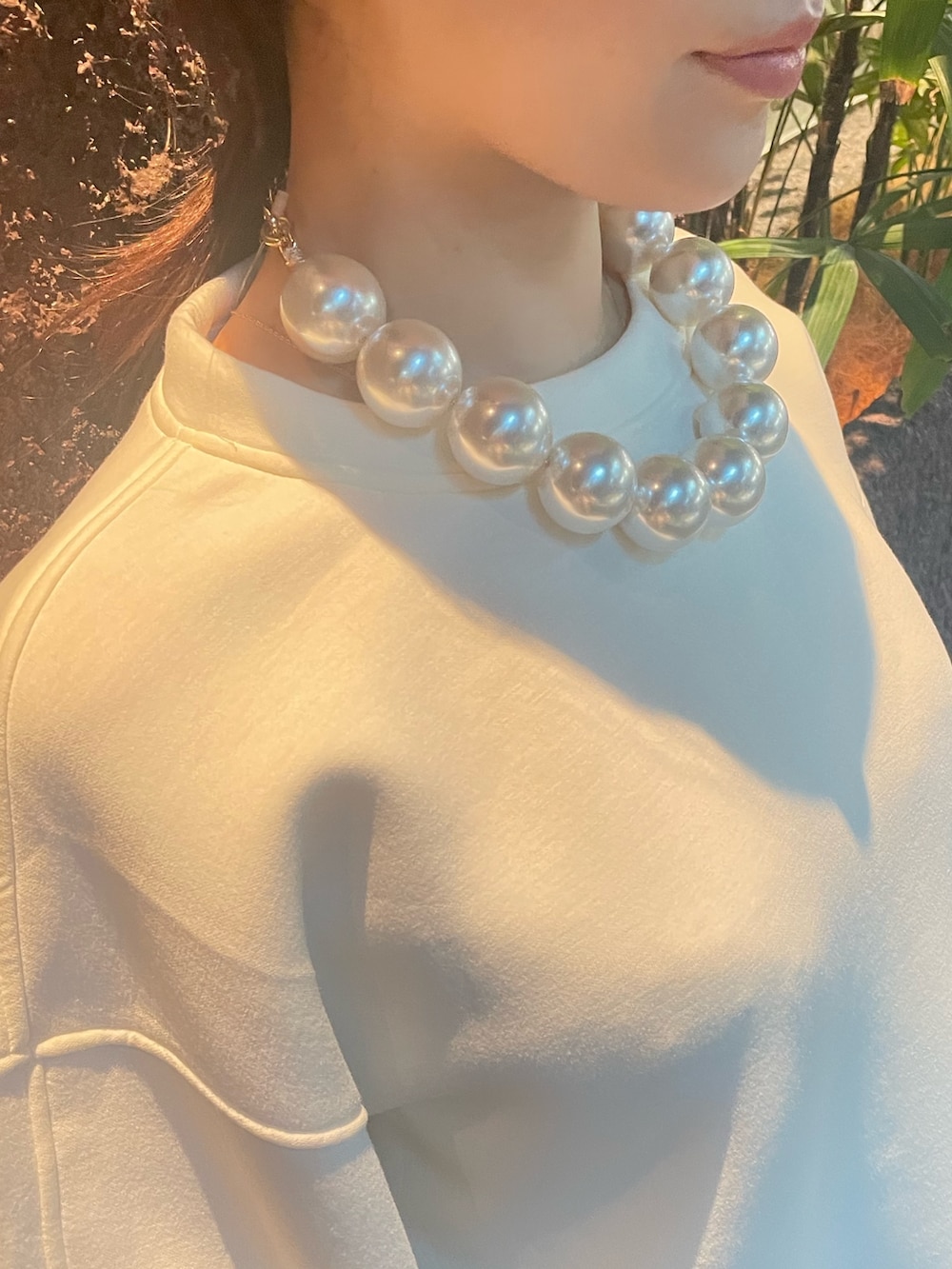 ベージュ系のスカート、ホワイト系のスウェット、その他のネックレスを着用したレディースの秋コーディネートの5枚目の写真