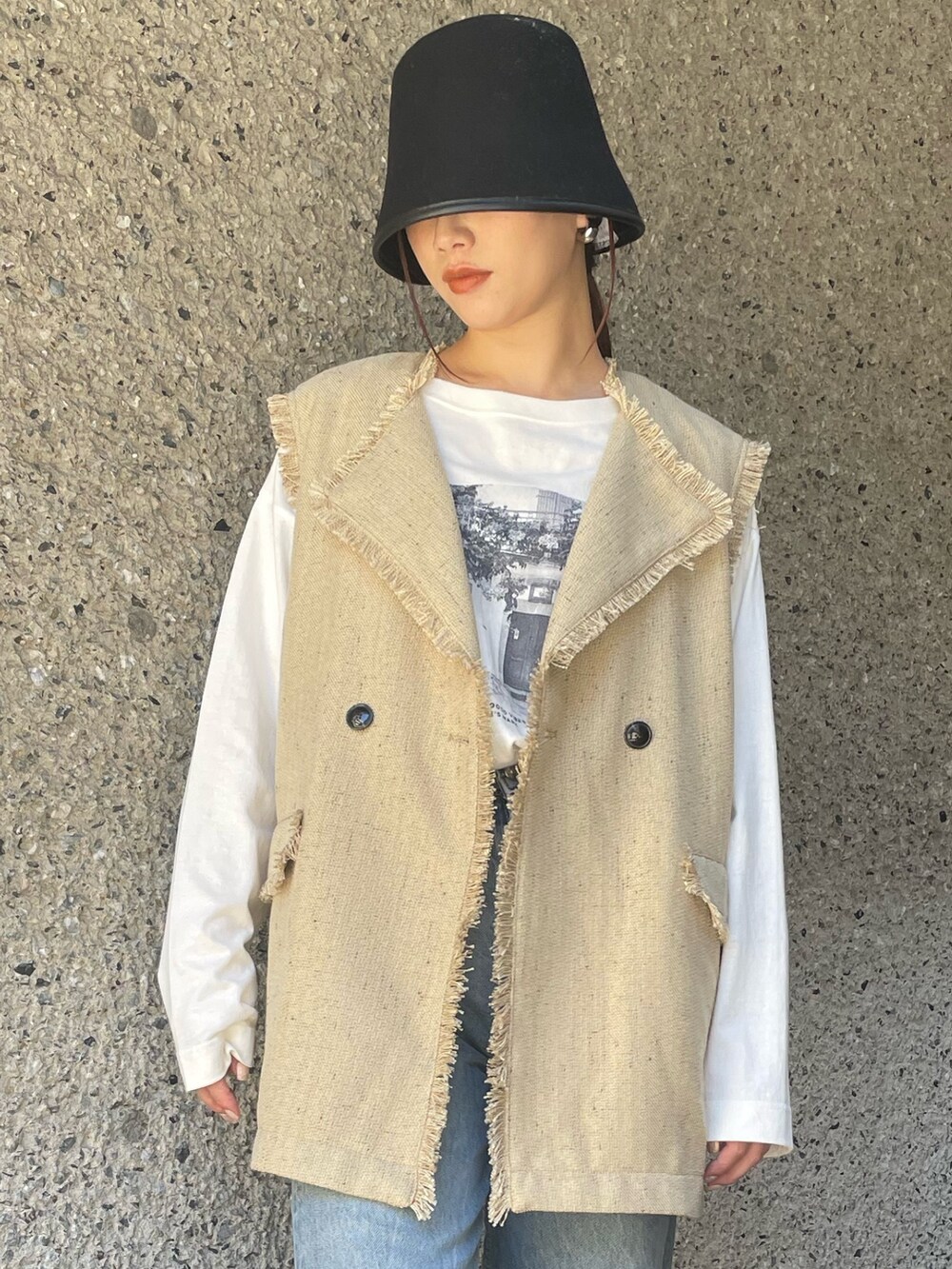 ベージュ系のベスト、ブラック系のハットを着用したレディースの冬コーディネートの6枚目の写真