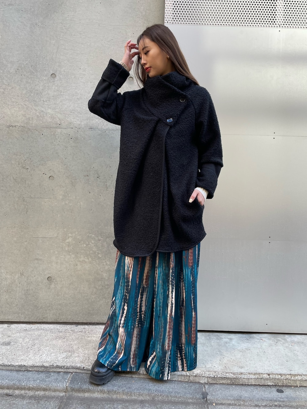 ブラック系のその他アウター、ベージュ系のニット/セーター、ブルー系のその他パンツを着用したレディースの冬コーディネートの3枚目の写真