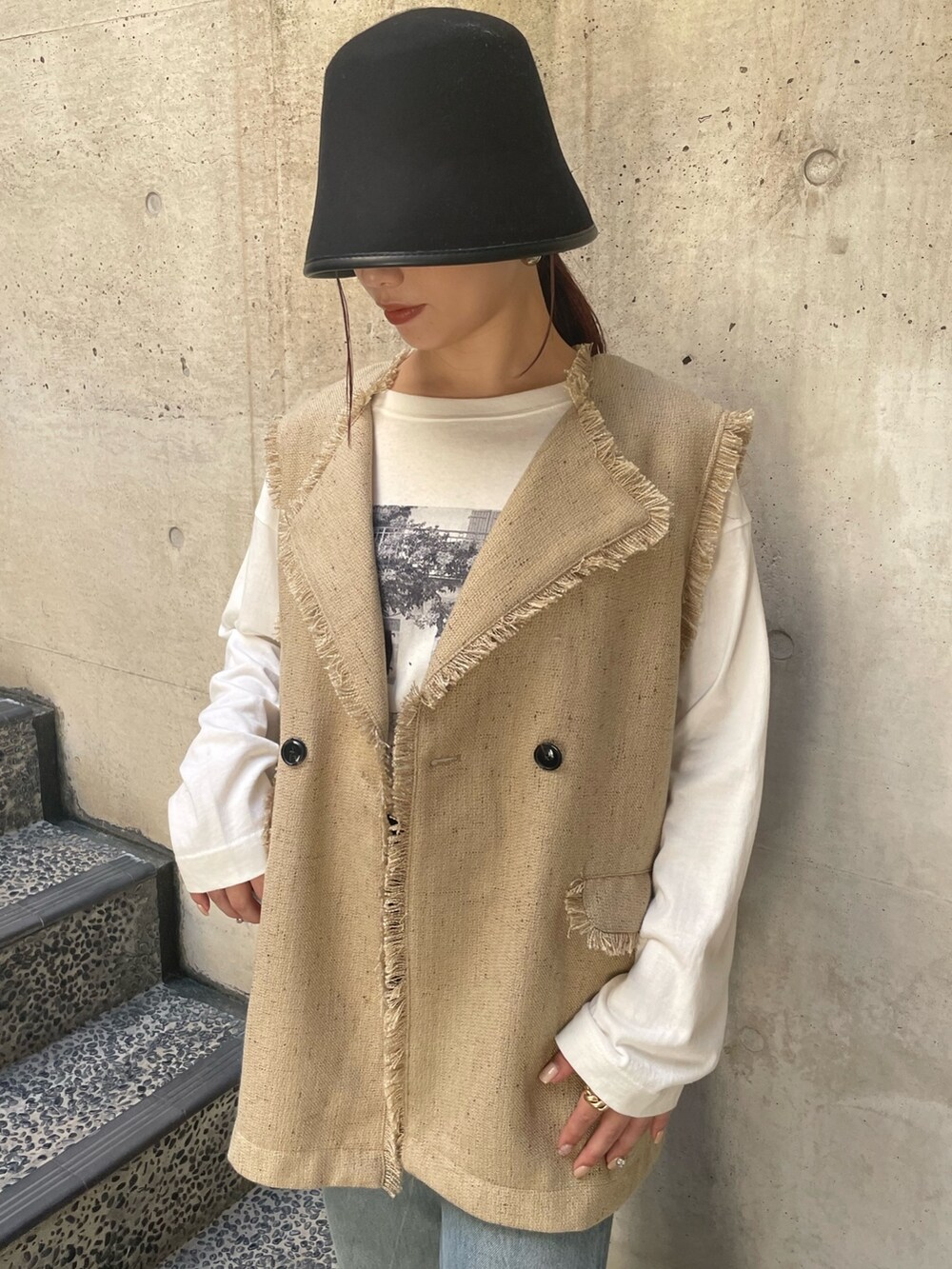 ベージュ系のベスト、ブラック系のハットを着用したレディースの冬コーディネートの7枚目の写真