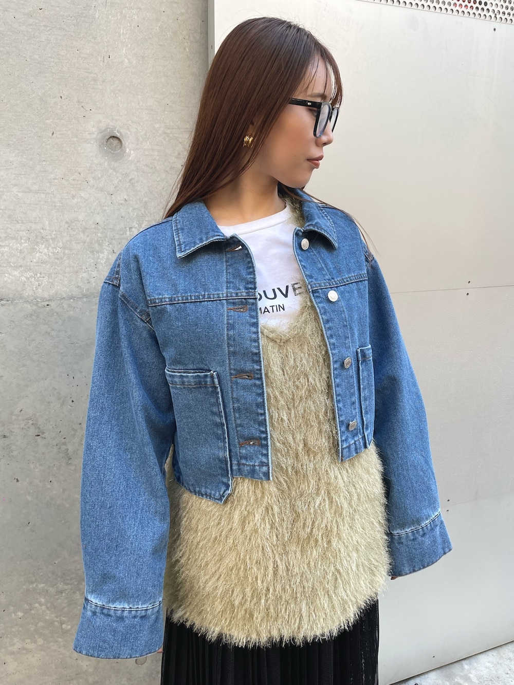 グリーン系のベスト、ブラック系のスカート、ブルー系のデニムジャケットを着用したレディースの冬コーディネートの3枚目の写真