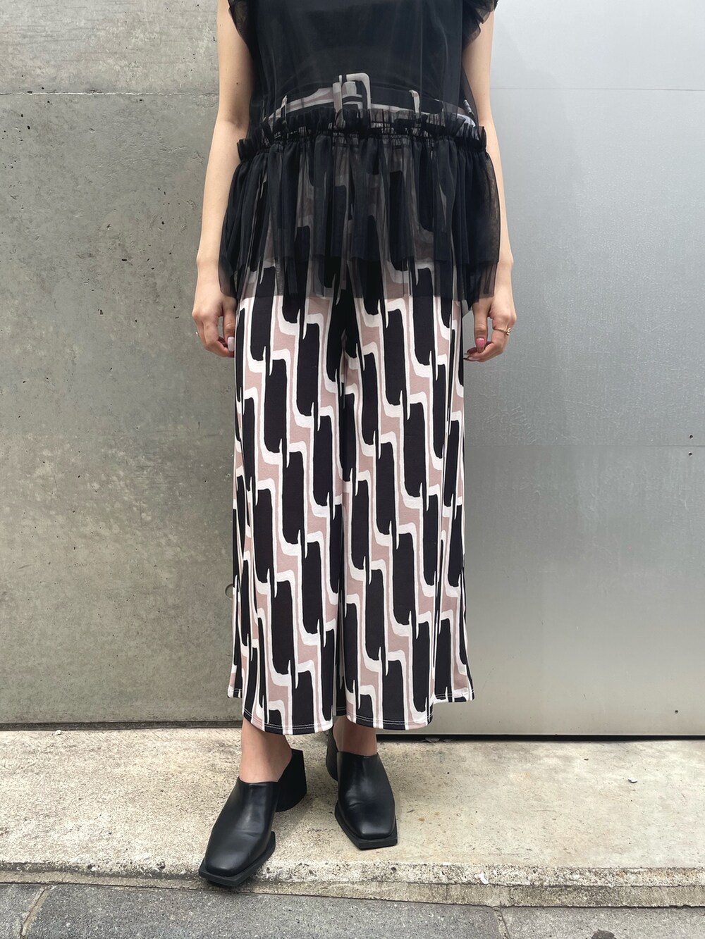 ブラック系のTシャツ/カットソー、ブラック系のその他パンツ、ブラック系のハットを着用したレディースの春コーディネートの3枚目の写真