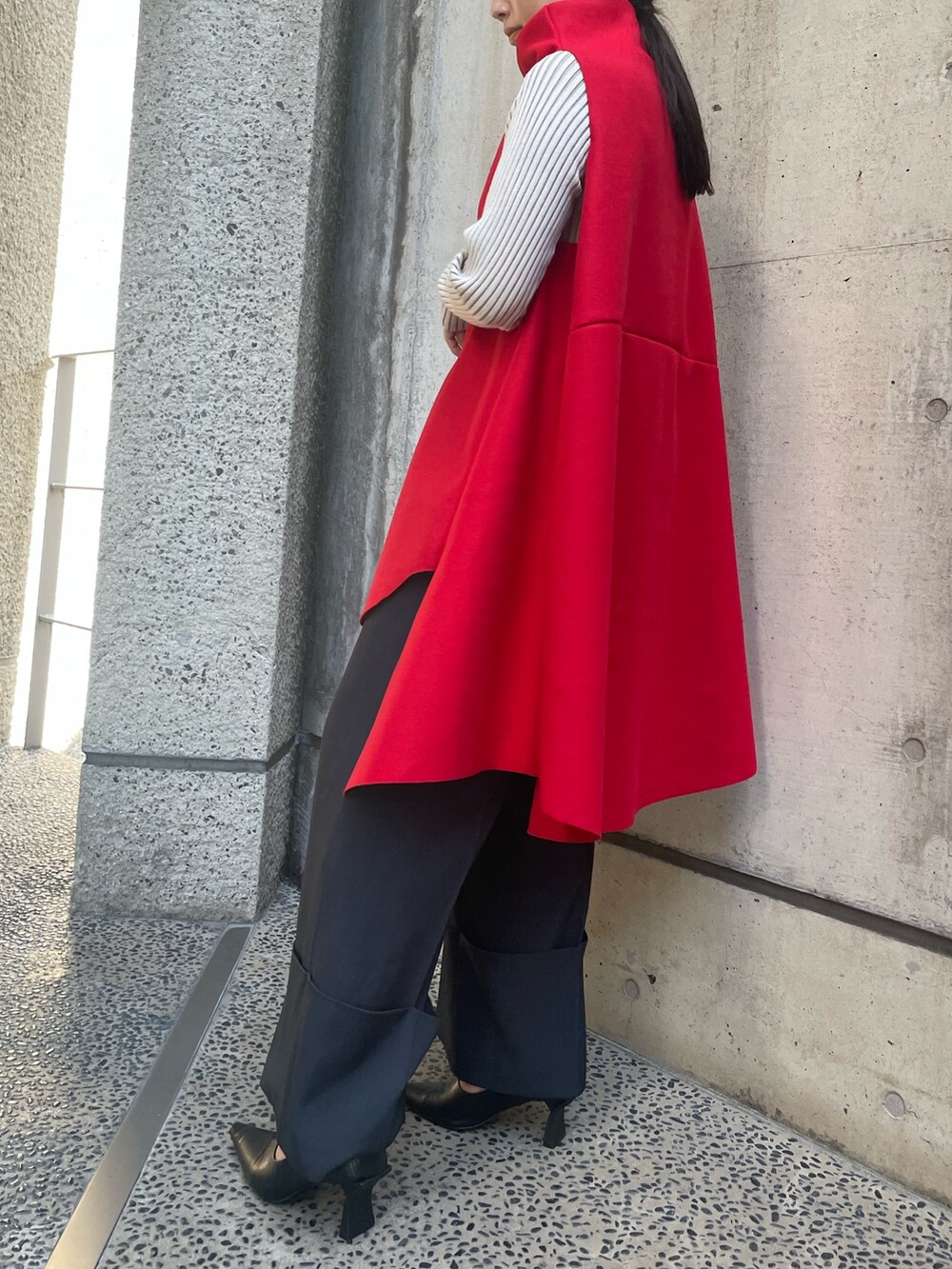 レッド系のベスト、ホワイト系のニット/セーター、ブラック系のその他パンツを着用したレディースの秋コーディネートの4枚目の写真