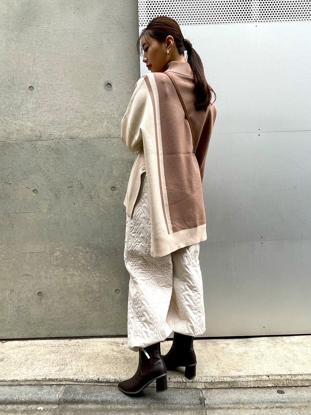 ブラウン系のショルダーバッグ、ベージュ系のニット/セーター、ホワイト系のその他パンツを着用したレディースの冬コーディネートの2枚目の写真