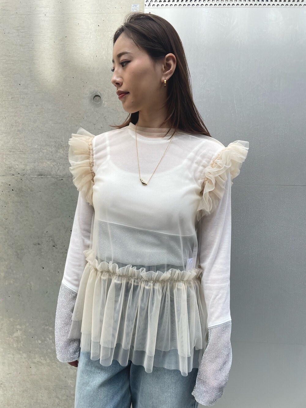 ホワイト系のTシャツ/カットソー、ブルー系のデニムパンツ、ベージュ系のスニーカーを着用したレディースの春コーディネートの2枚目の写真