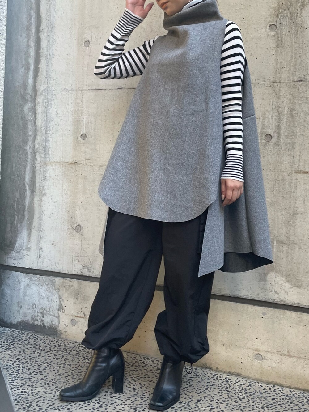 グレー系のベスト、ホワイト系のニット/セーターを着用したレディースの秋コーディネートの3枚目の写真