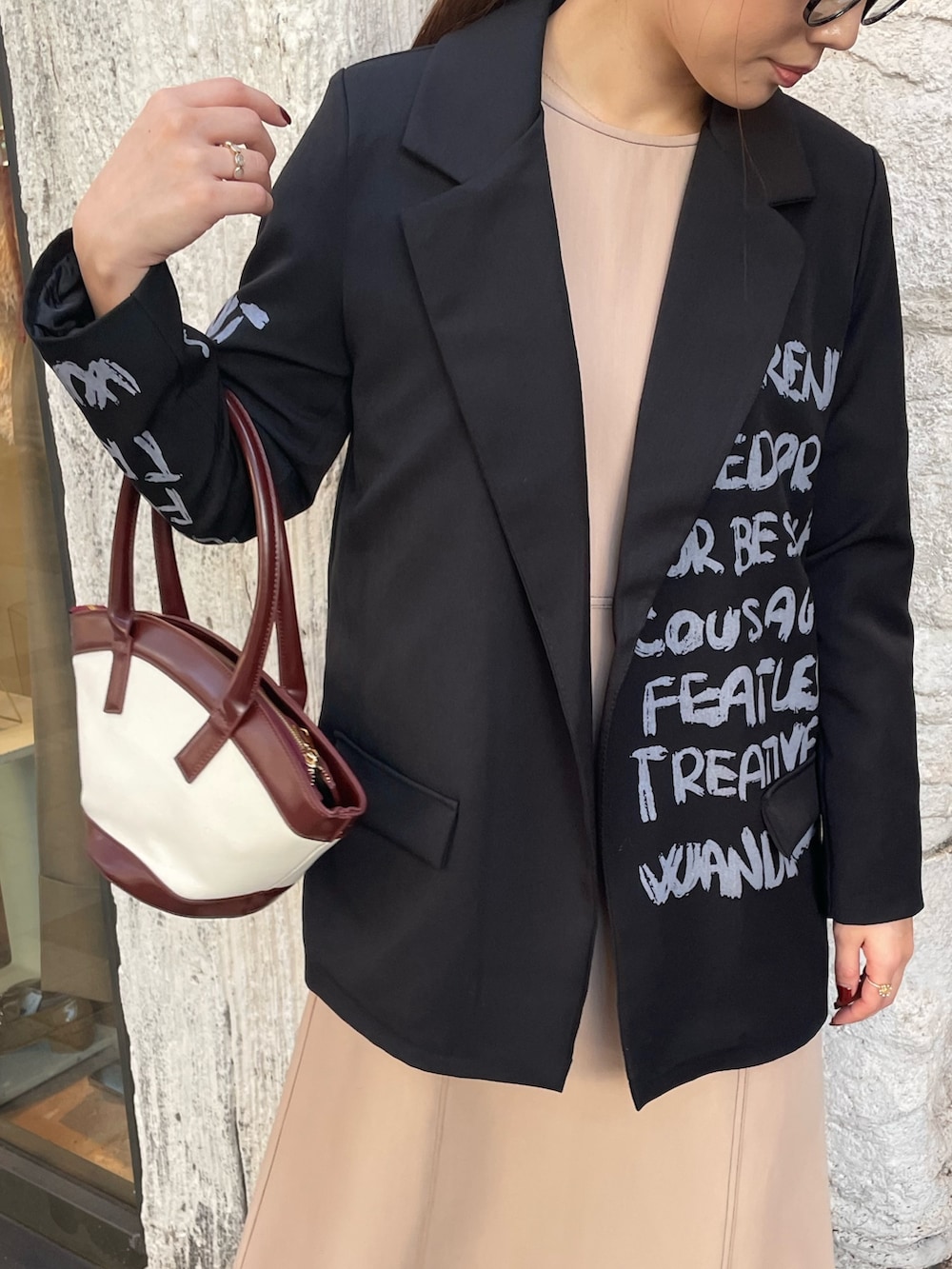 ベージュ系のワンピース、ブラウン系のハンドバッグ、ブラック系のサングラスを着用したレディースの秋コーディネートの3枚目の写真