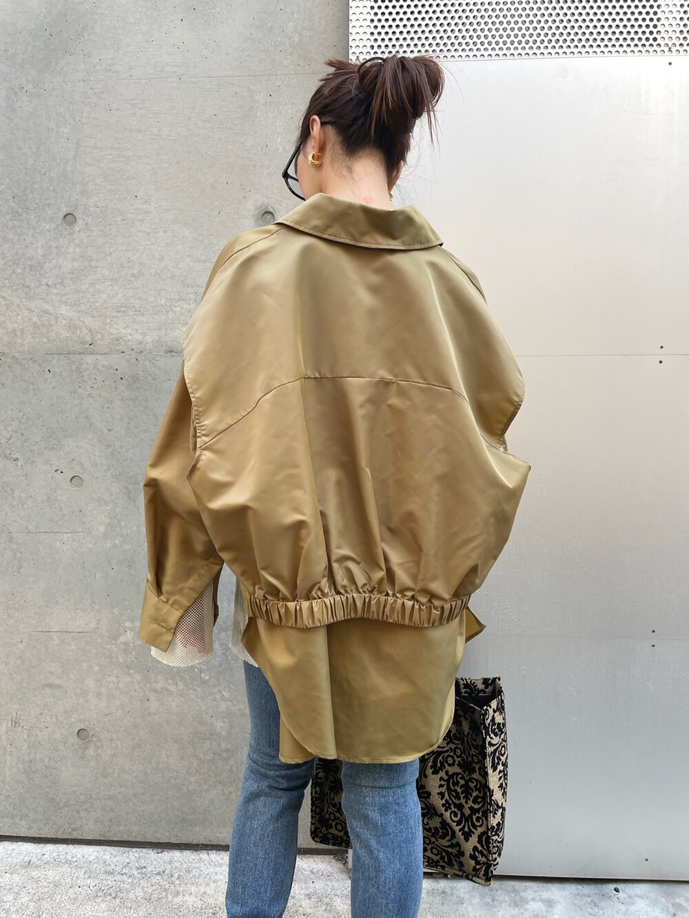 ホワイト系のTシャツ/カットソー、ブルー系のデニムパンツ、ブラック系のブーツを着用したレディースの冬コーディネートの5枚目の写真