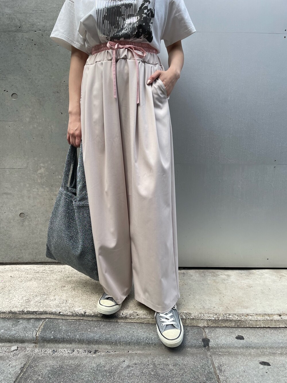 ベージュ系のその他パンツ、シルバー系のトートバッグ、シルバー系のTシャツ/カットソーを着用したレディースの春コーディネートの3枚目の写真