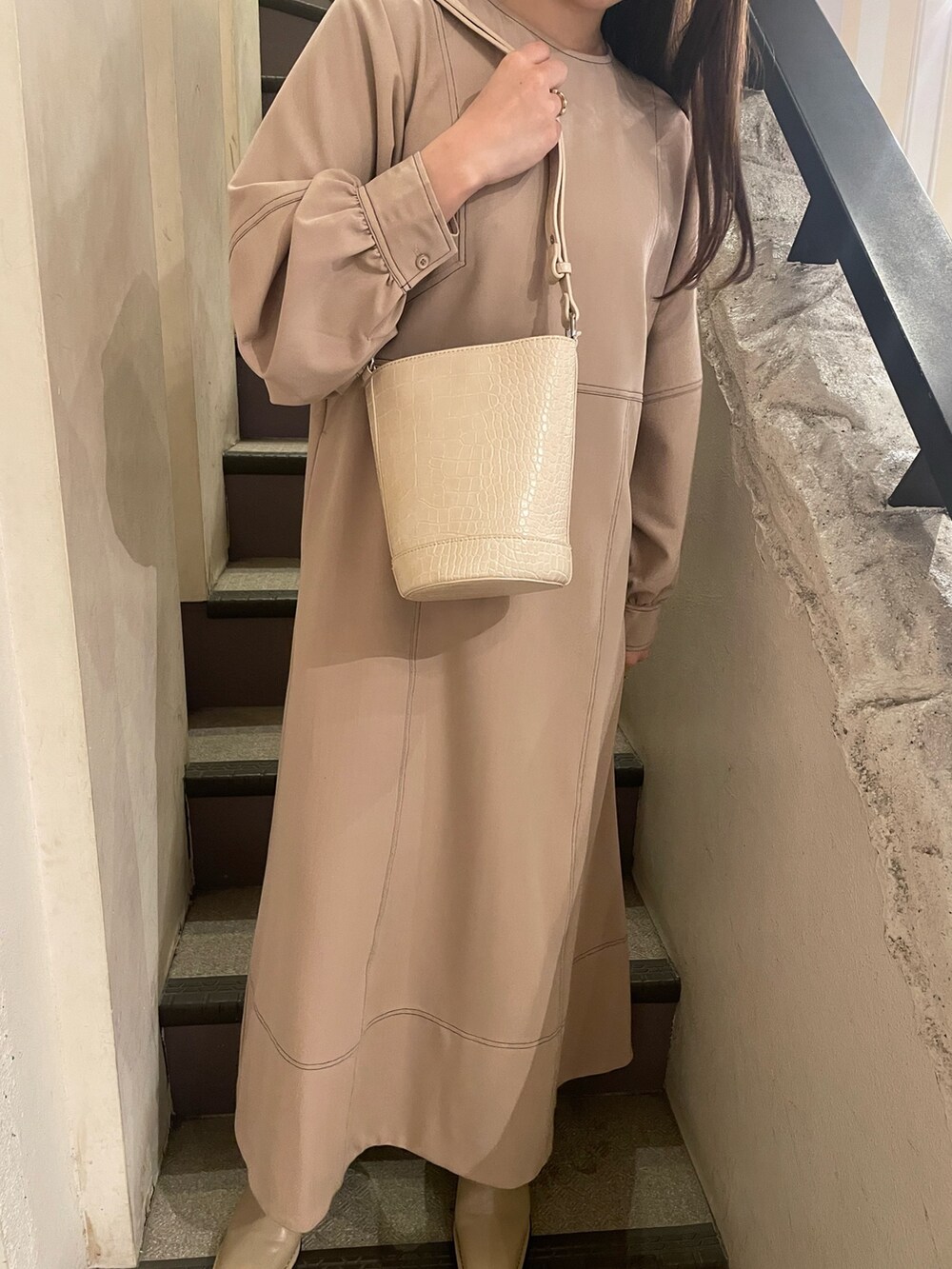 ホワイト系のショルダーバッグ、グレー系のワンピースを着用したレディースの冬コーディネートの9枚目の写真