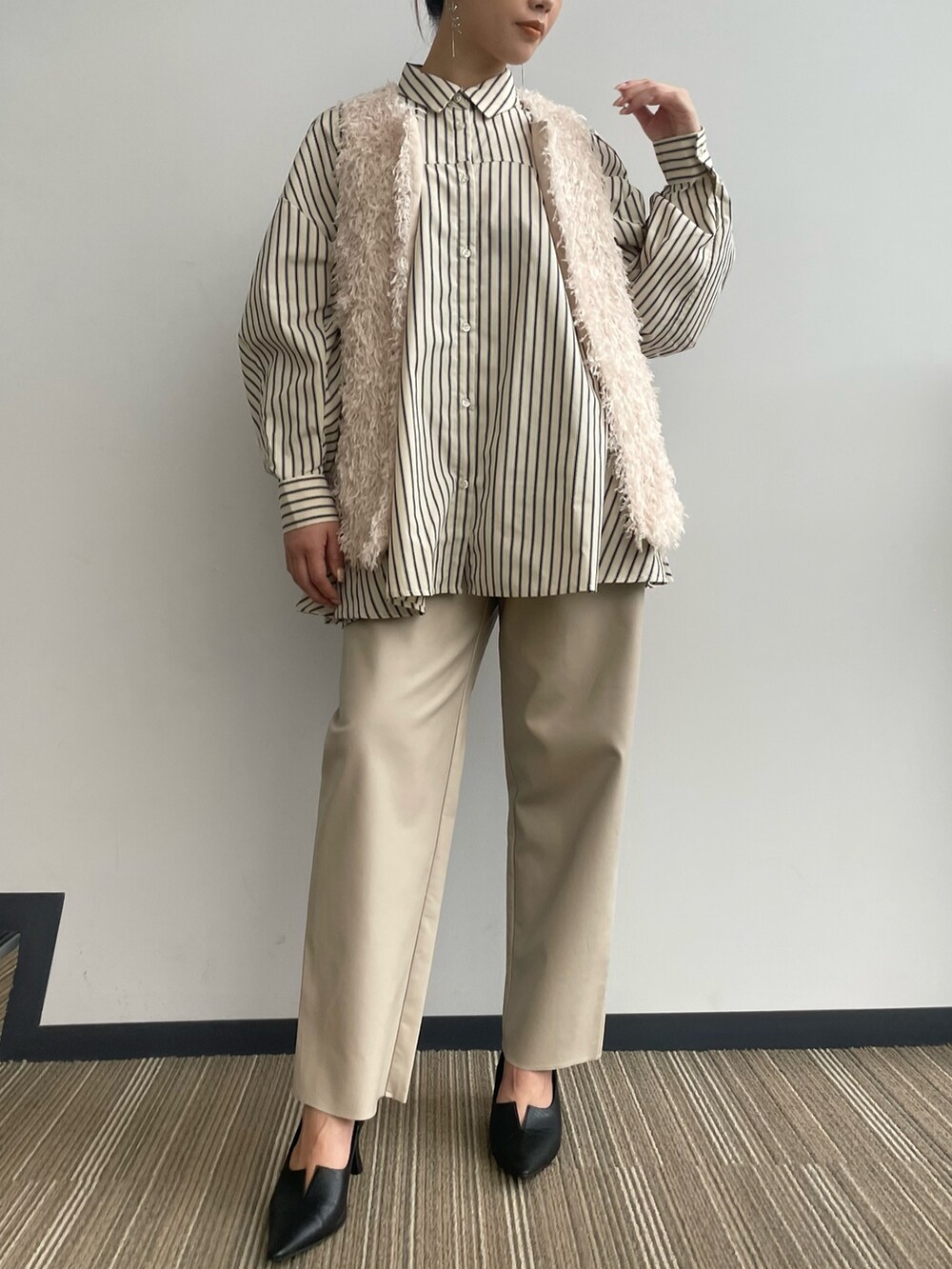 ベージュ系のベストを着用したレディースの冬コーディネートの5枚目の写真