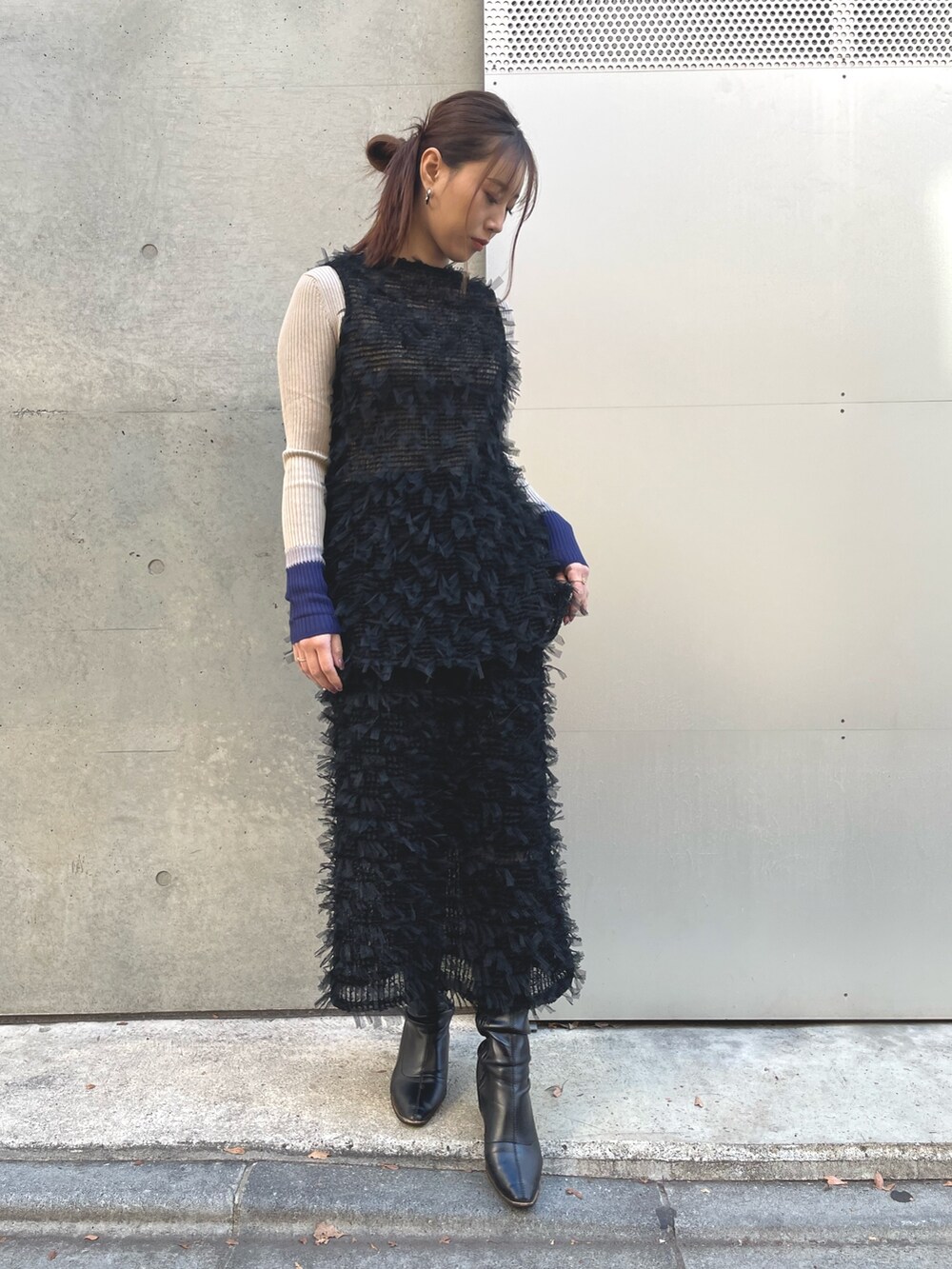 ベージュ系のニット/セーター、ブラック系のベスト、ブラック系のスカートを着用したレディースの冬コーディネートの2枚目の写真