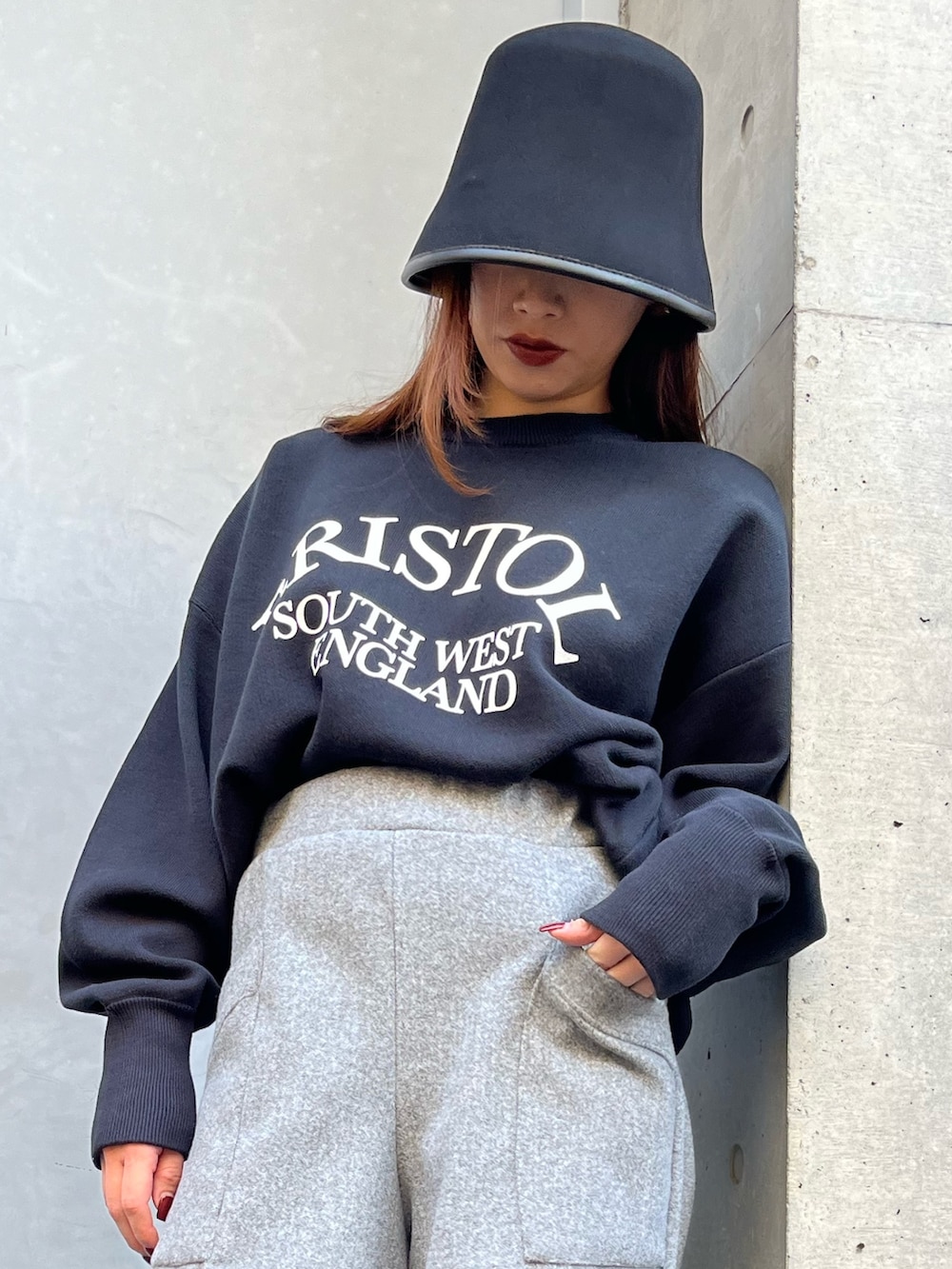 グレー系のその他パンツ、ブラック系のニット/セーター、ブラック系のハットを着用したレディースの冬コーディネートの9枚目の写真