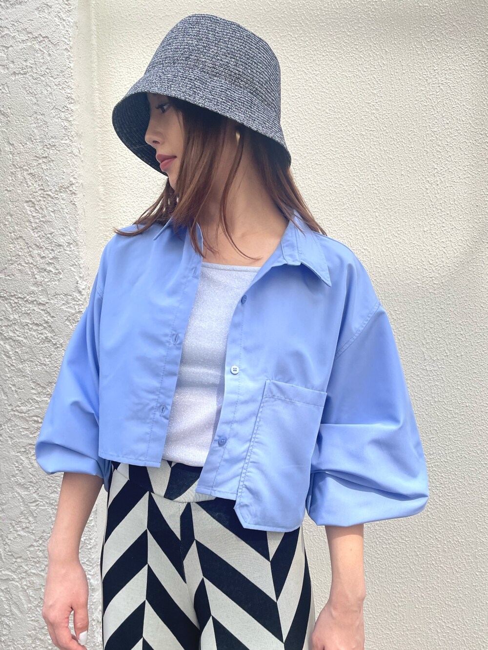 ブルー系のシャツ/ブラウス、ブラック系のその他パンツ、ブラック系のハットを着用したレディースの春コーディネートの2枚目の写真