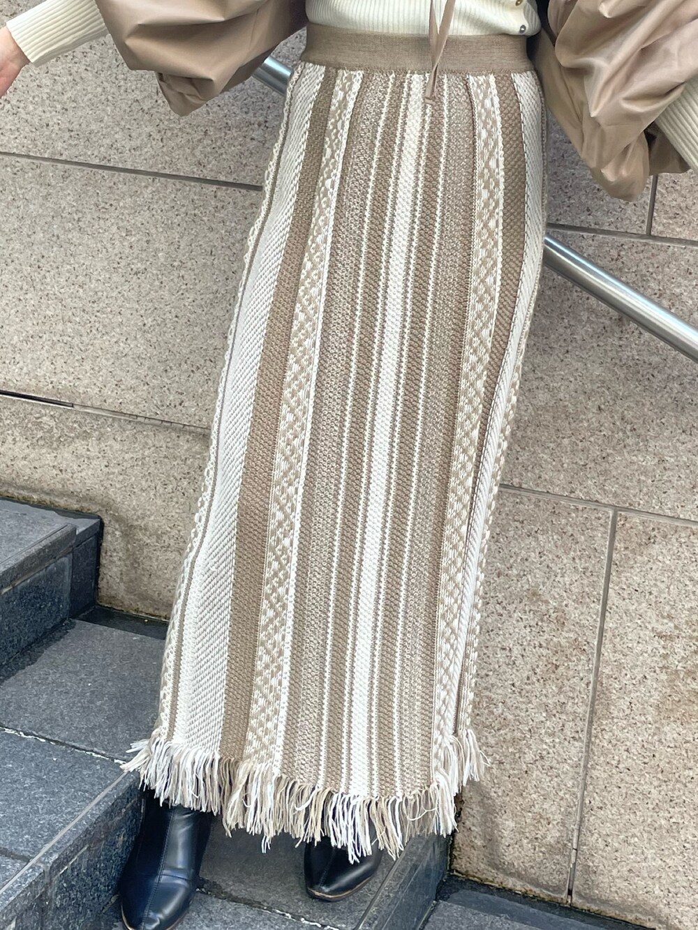 ベージュ系のスカート、ブラウン系のカーディガン/ボレロ、グリーン系のハットを着用したレディースの秋コーディネートの6枚目の写真