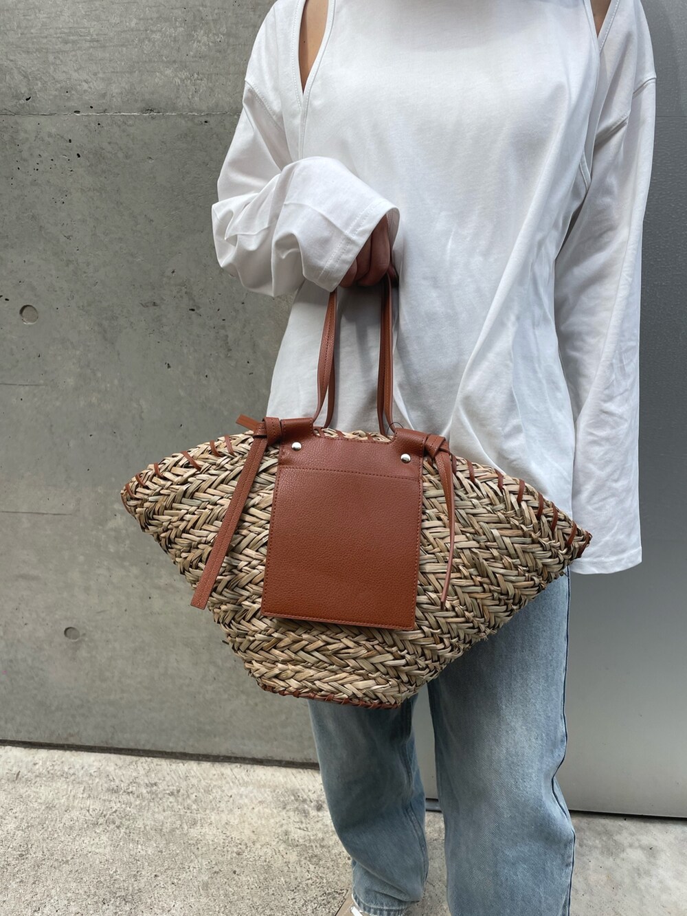 ベージュ系のスニーカー、ブルー系のデニムパンツ、ホワイト系のTシャツ/カットソーを着用したレディースの春コーディネートの3枚目の写真