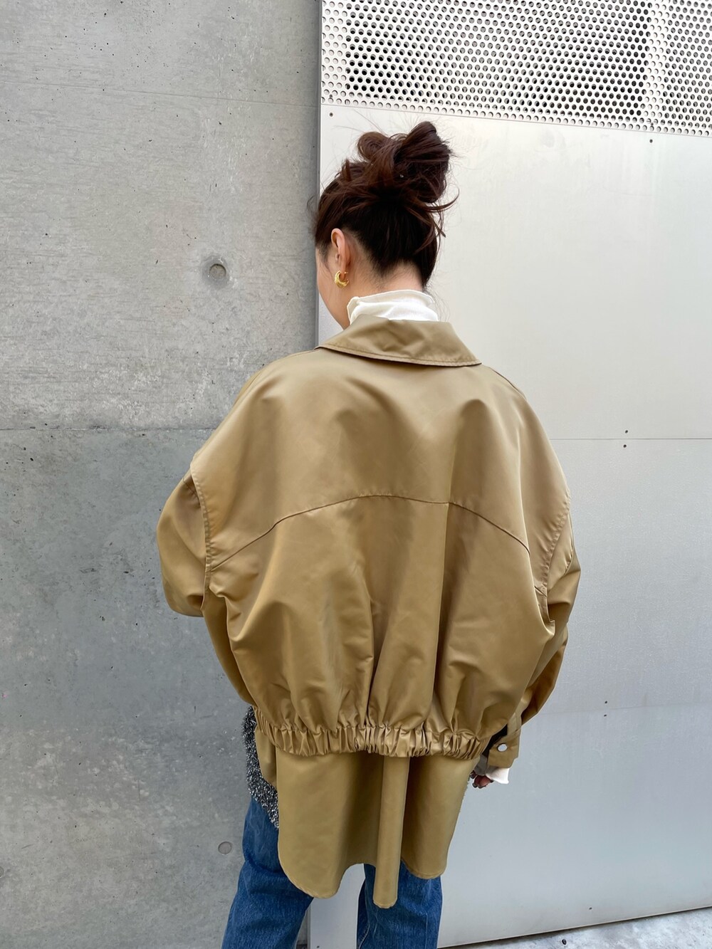 ブラック系のベスト、ベージュ系のブルゾン、ホワイト系のTシャツ/カットソーを着用したレディースの冬コーディネートの4枚目の写真