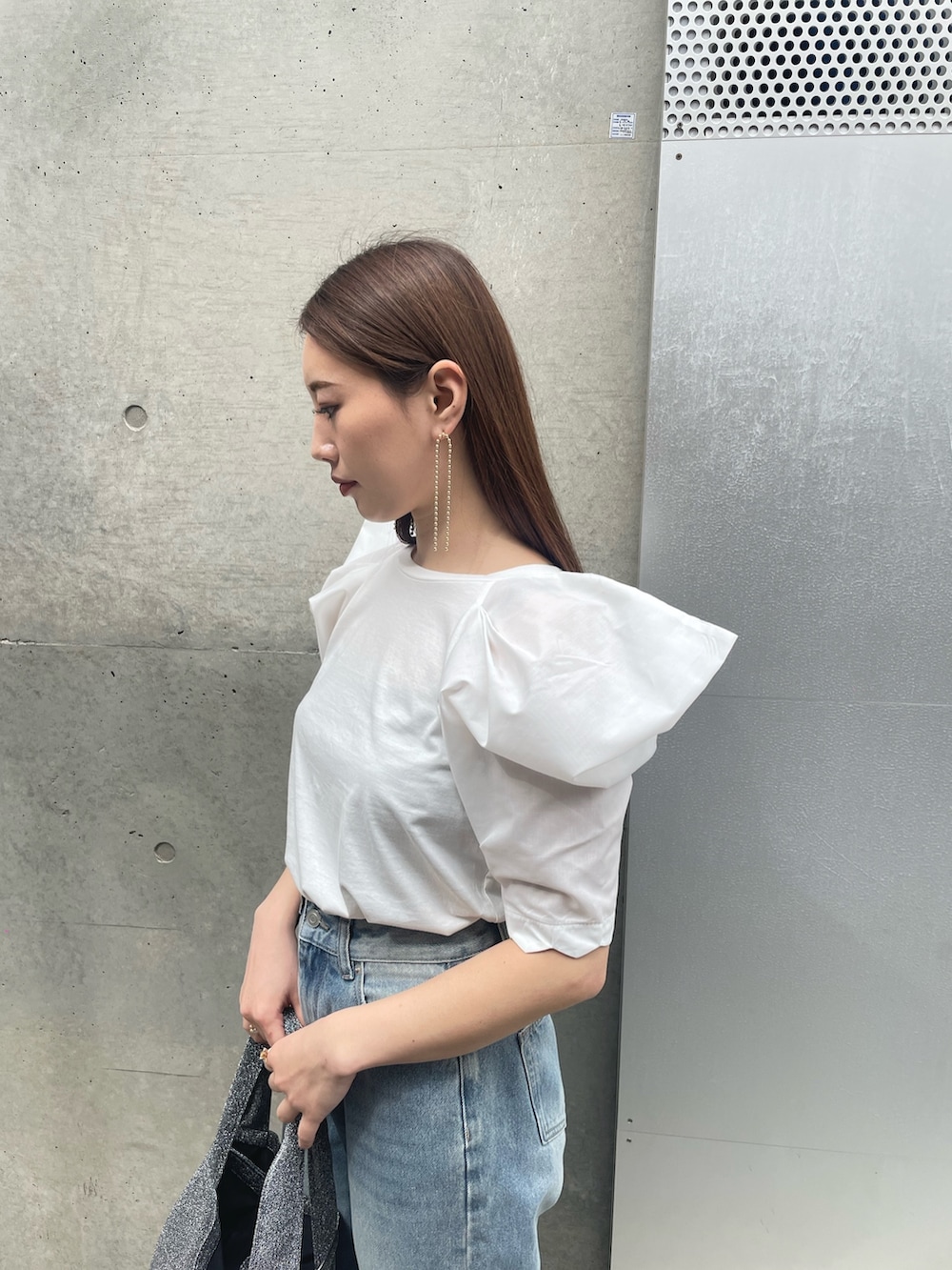 ホワイト系のTシャツ/カットソー、シルバー系のトートバッグ、ブルー系のデニムパンツを着用したレディースの春コーディネートの4枚目の写真