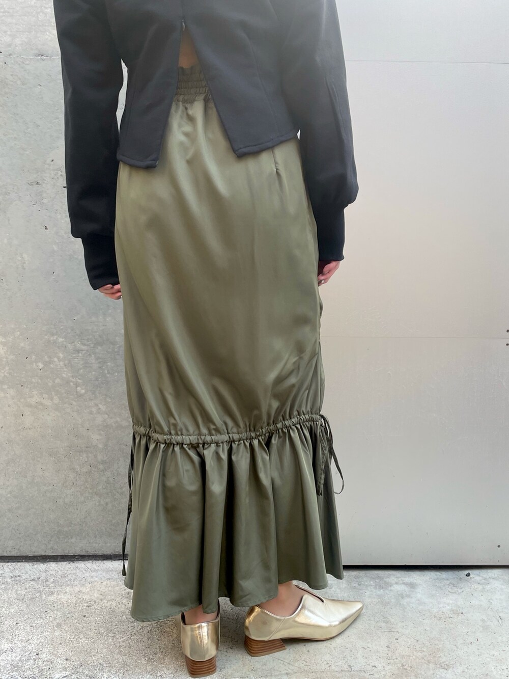 ブラック系のスウェット、グリーン系のスカートを着用したレディースの春コーディネートの5枚目の写真