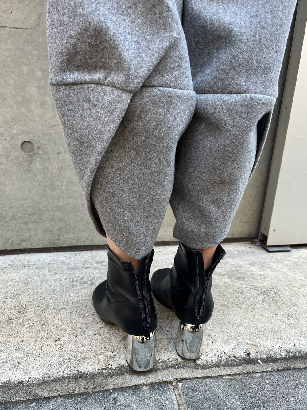 グレー系のその他パンツ、ブラック系のニット/セーター、ブラック系のハットを着用したレディースの冬コーディネートの8枚目の写真