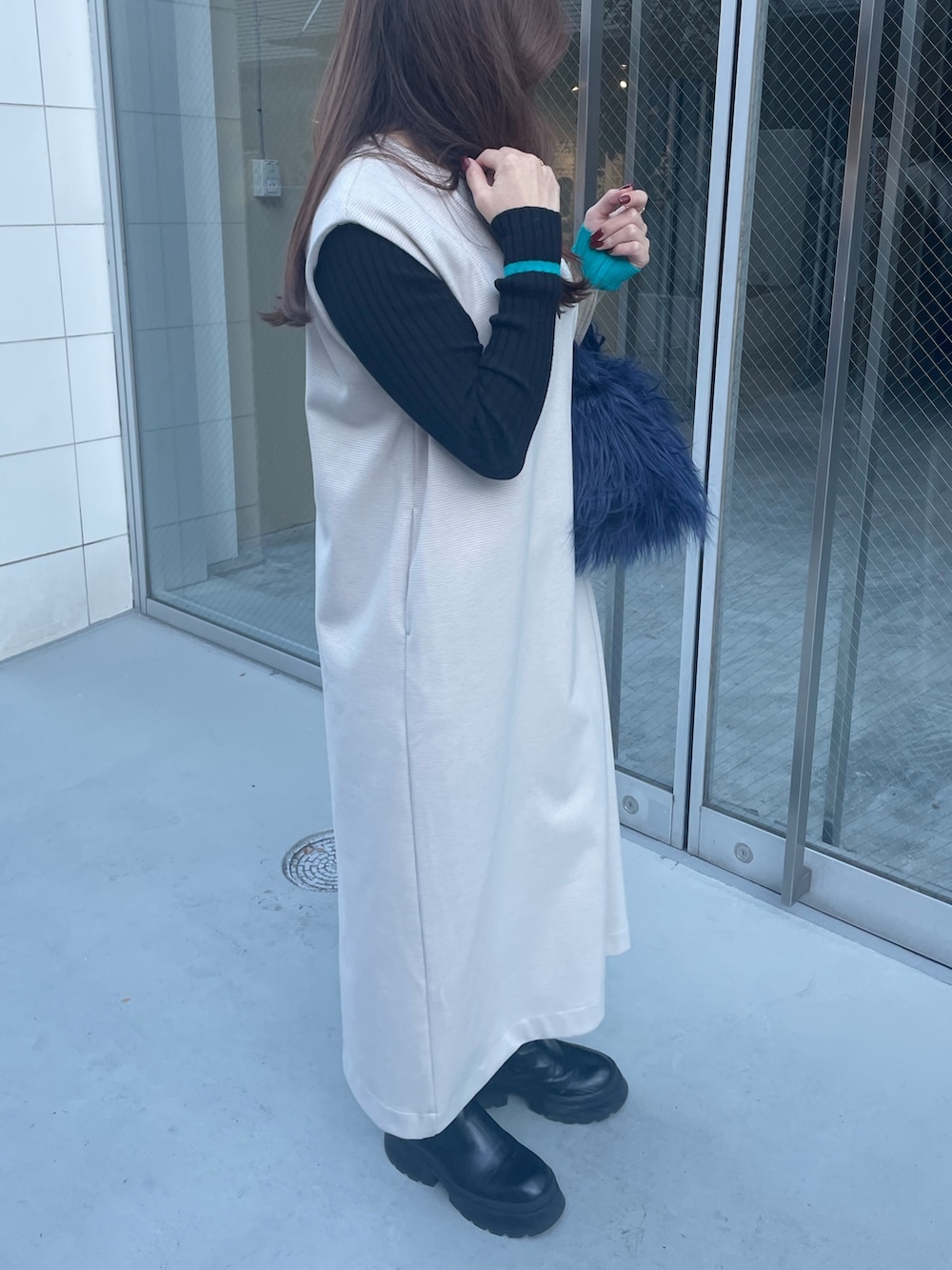 ブルー系のハンドバッグ、ブラック系のニット/セーター、ホワイト系のワンピースを着用したレディースの秋コーディネートの3枚目の写真