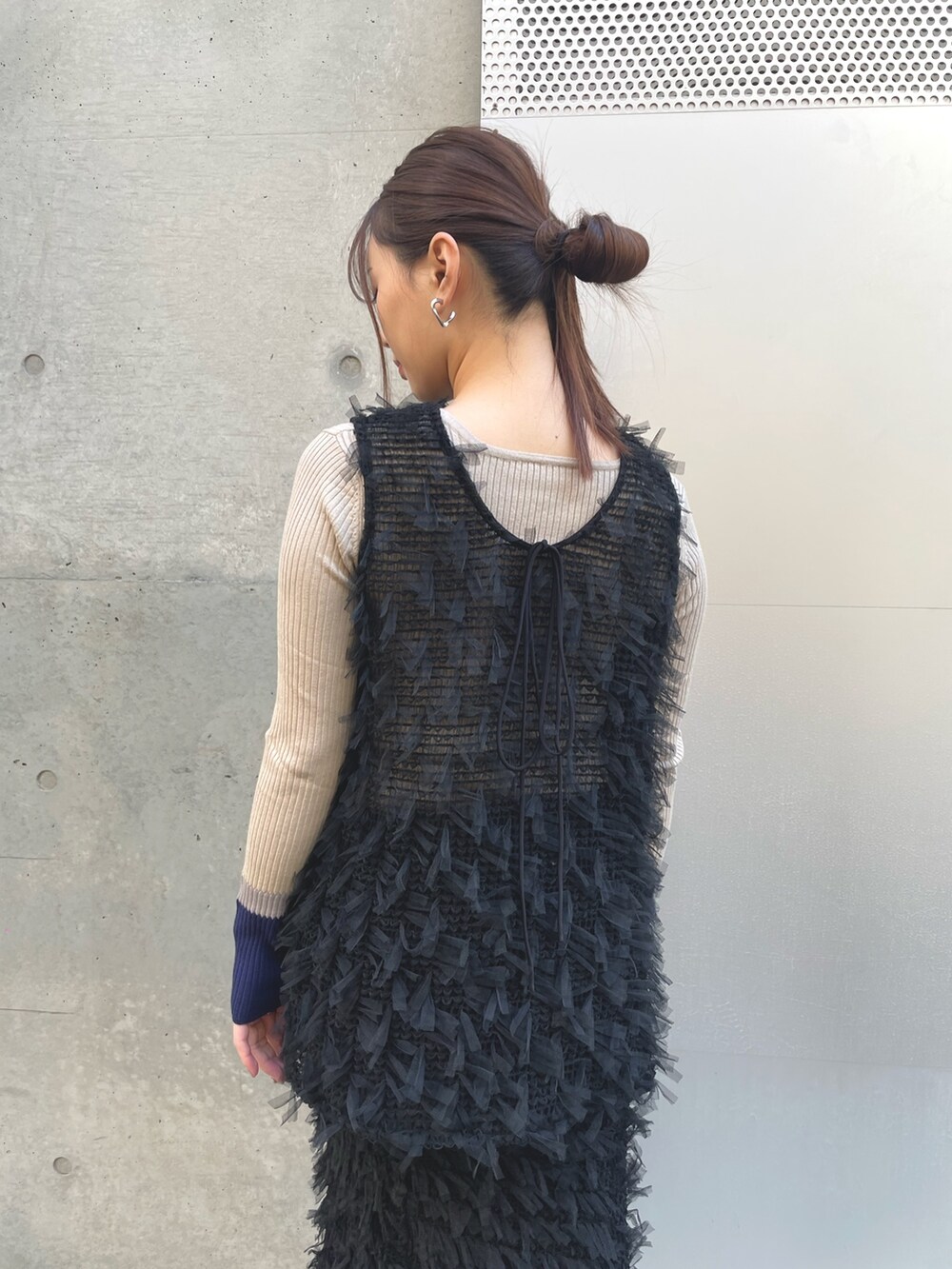 ベージュ系のニット/セーター、ブラック系のベスト、ブラック系のスカートを着用したレディースの冬コーディネートの4枚目の写真