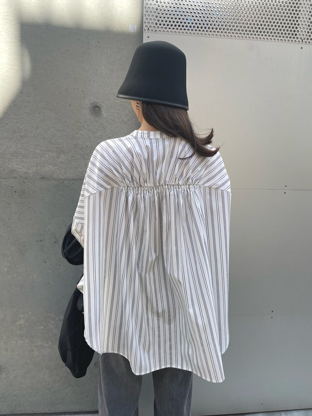 ホワイト系のシャツ/ブラウス、ブラック系のデニムパンツ、ブラック系のブルゾンを着用したレディースの春コーディネートの4枚目の写真