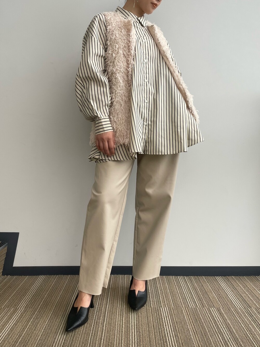 ベージュ系のベストを着用したレディースの冬コーディネートの7枚目の写真