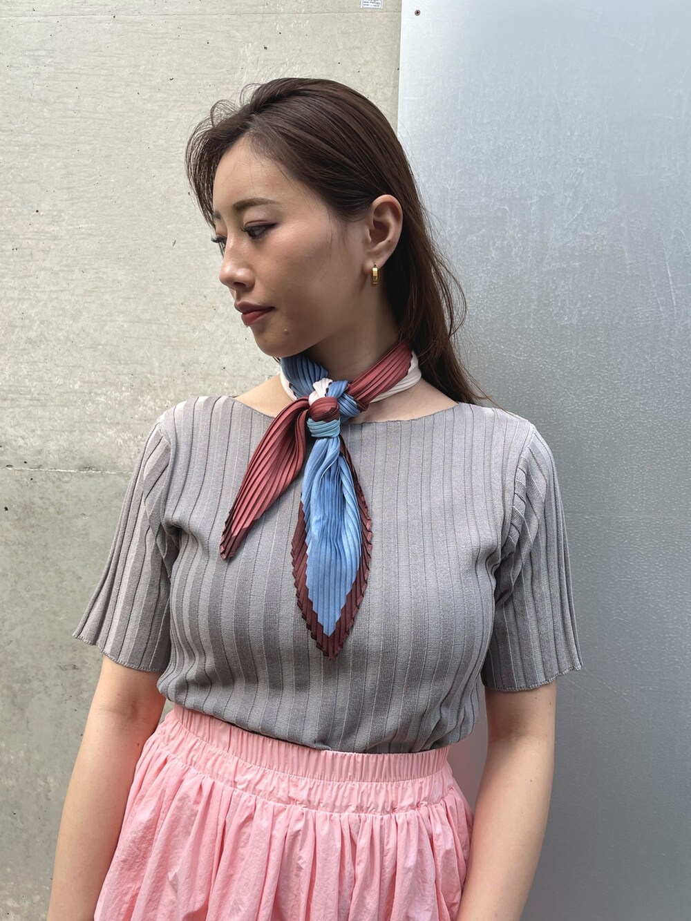 ベージュ系のスニーカー、ピンク系のスカートを着用したレディースの春コーディネートの2枚目の写真