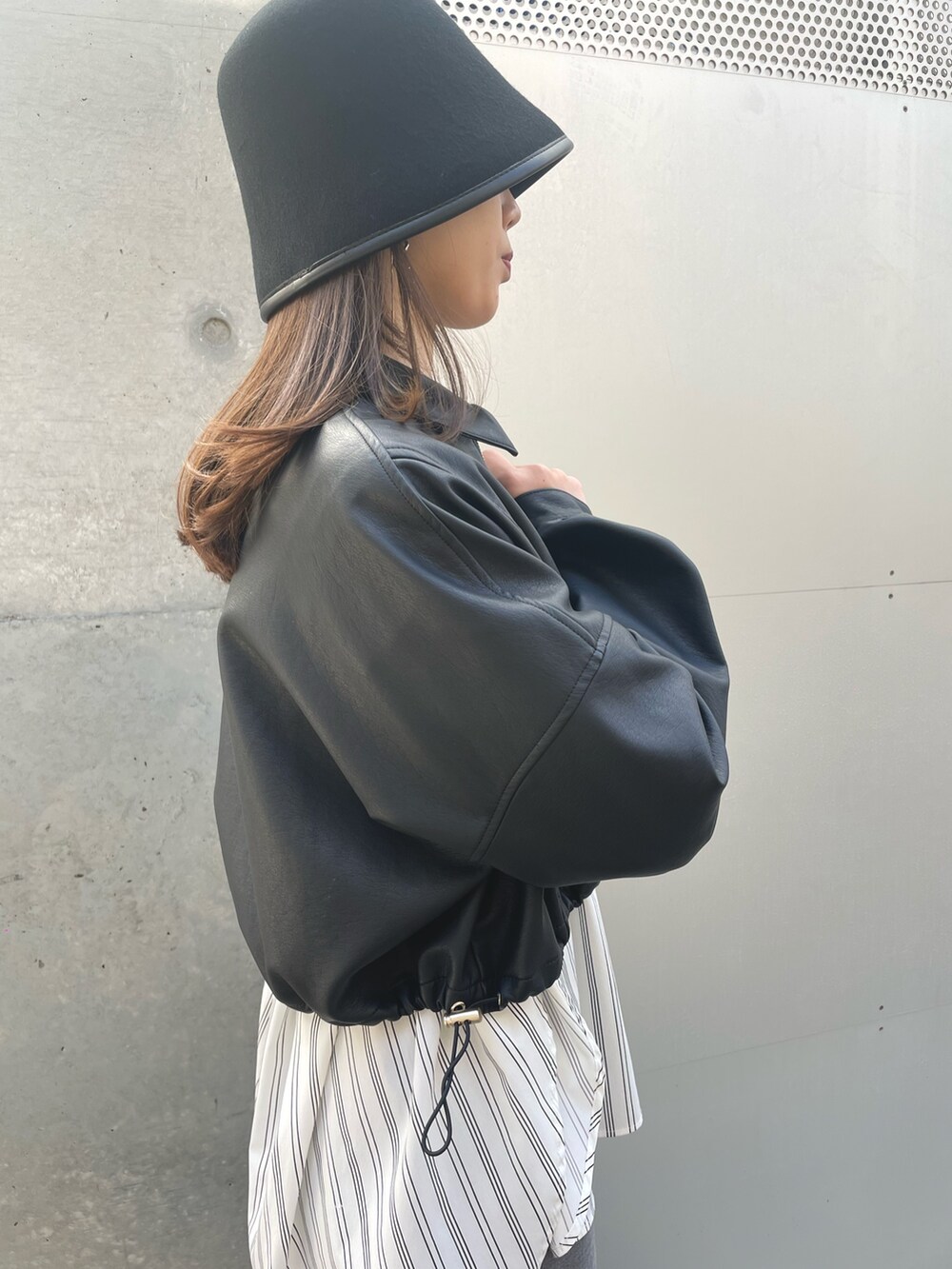 ホワイト系のシャツ/ブラウス、ブラック系のデニムパンツ、ブラック系のブルゾンを着用したレディースの春コーディネートの7枚目の写真