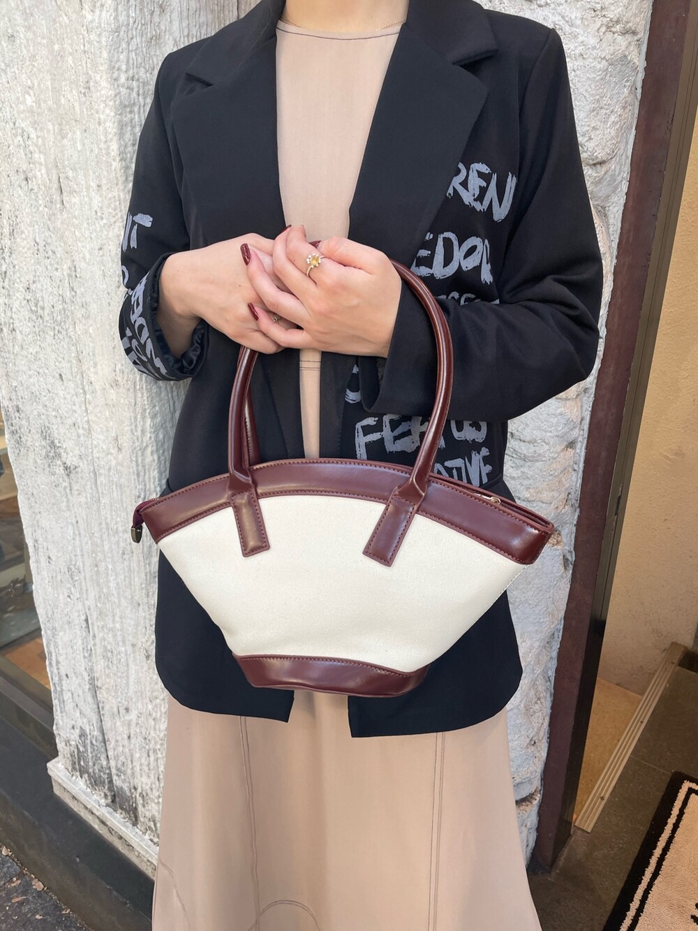 ベージュ系のワンピース、ブラウン系のハンドバッグ、ブラック系のサングラスを着用したレディースの秋コーディネートの7枚目の写真