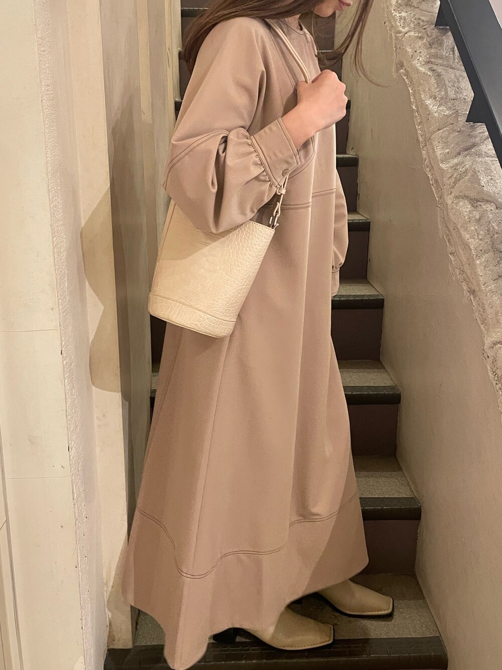 ホワイト系のショルダーバッグ、グレー系のワンピースを着用したレディースの冬コーディネートの3枚目の写真