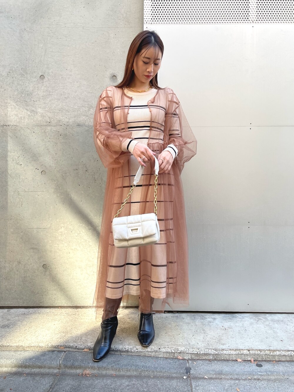 ベージュ系のワンピースを着用したレディースの冬コーディネートの3枚目の写真