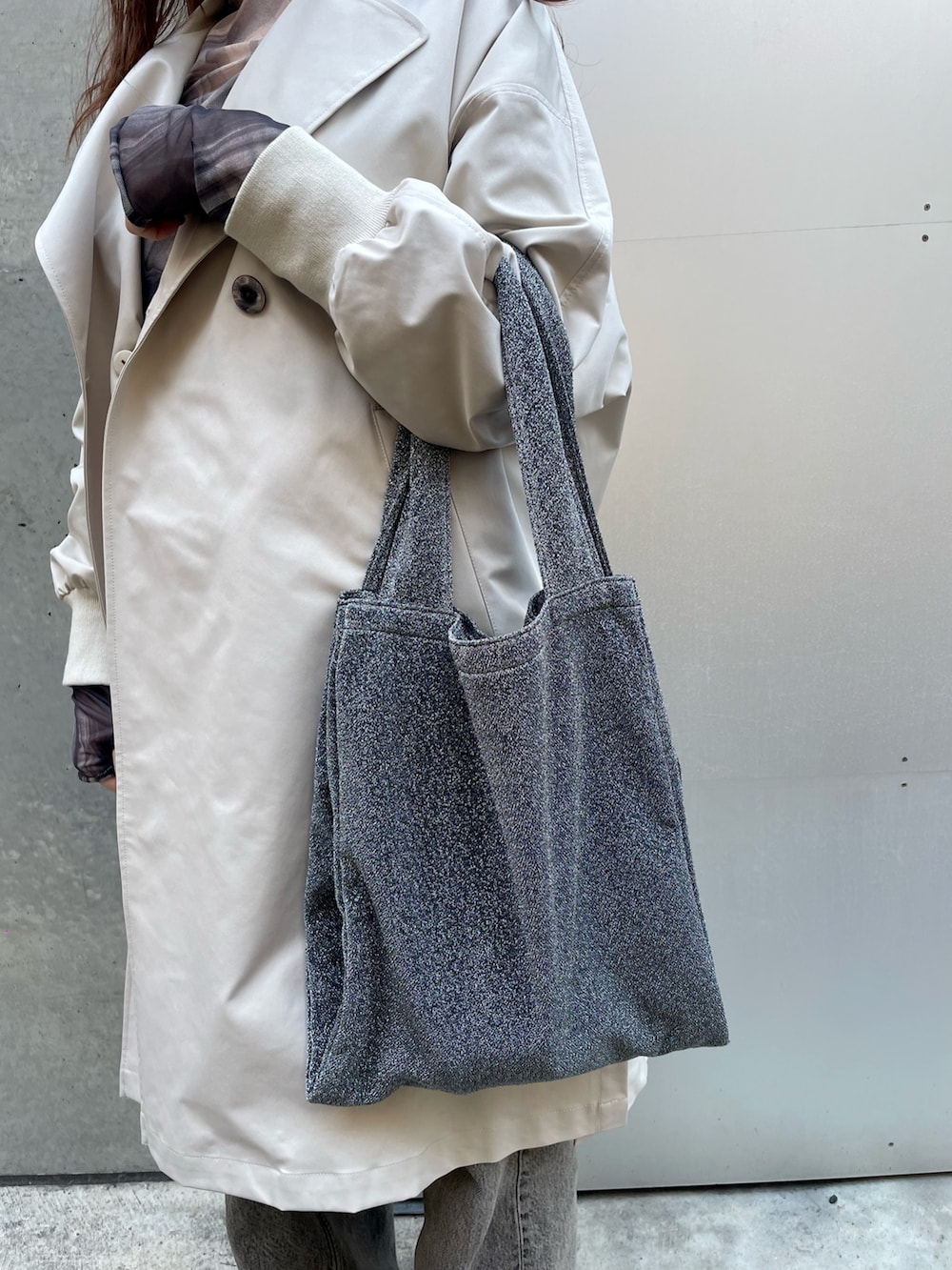 ベージュ系のトレンチコート、ブラック系のデニムパンツ、ホワイト系のスニーカーを着用したレディースの春コーディネートの8枚目の写真