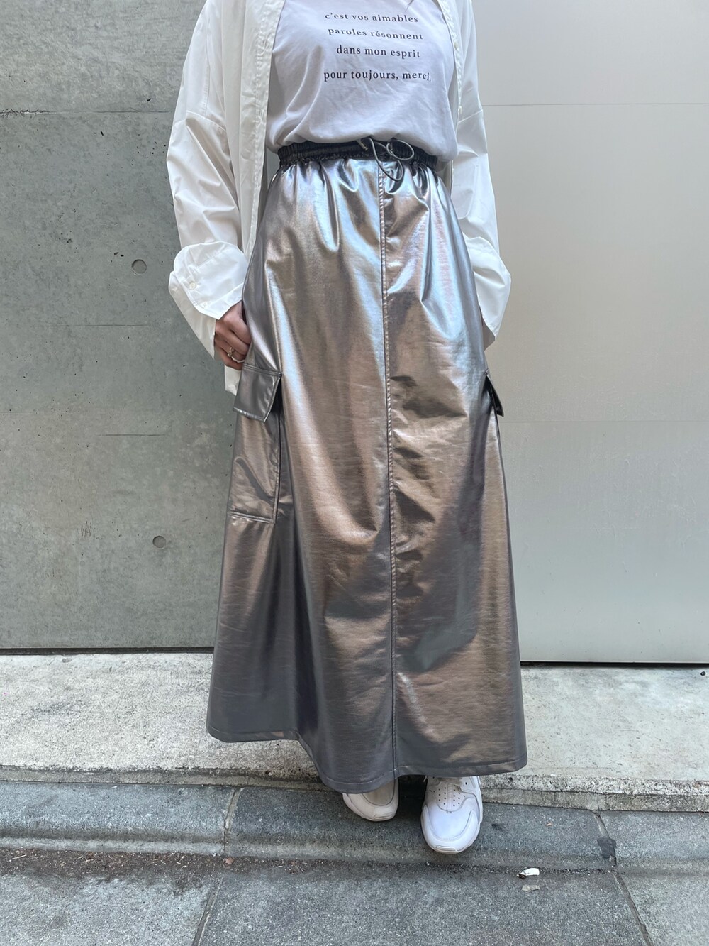 ホワイト系のスニーカー、ホワイト系のバッグ、シルバー系のスカートを着用したレディースの春コーディネートの7枚目の写真