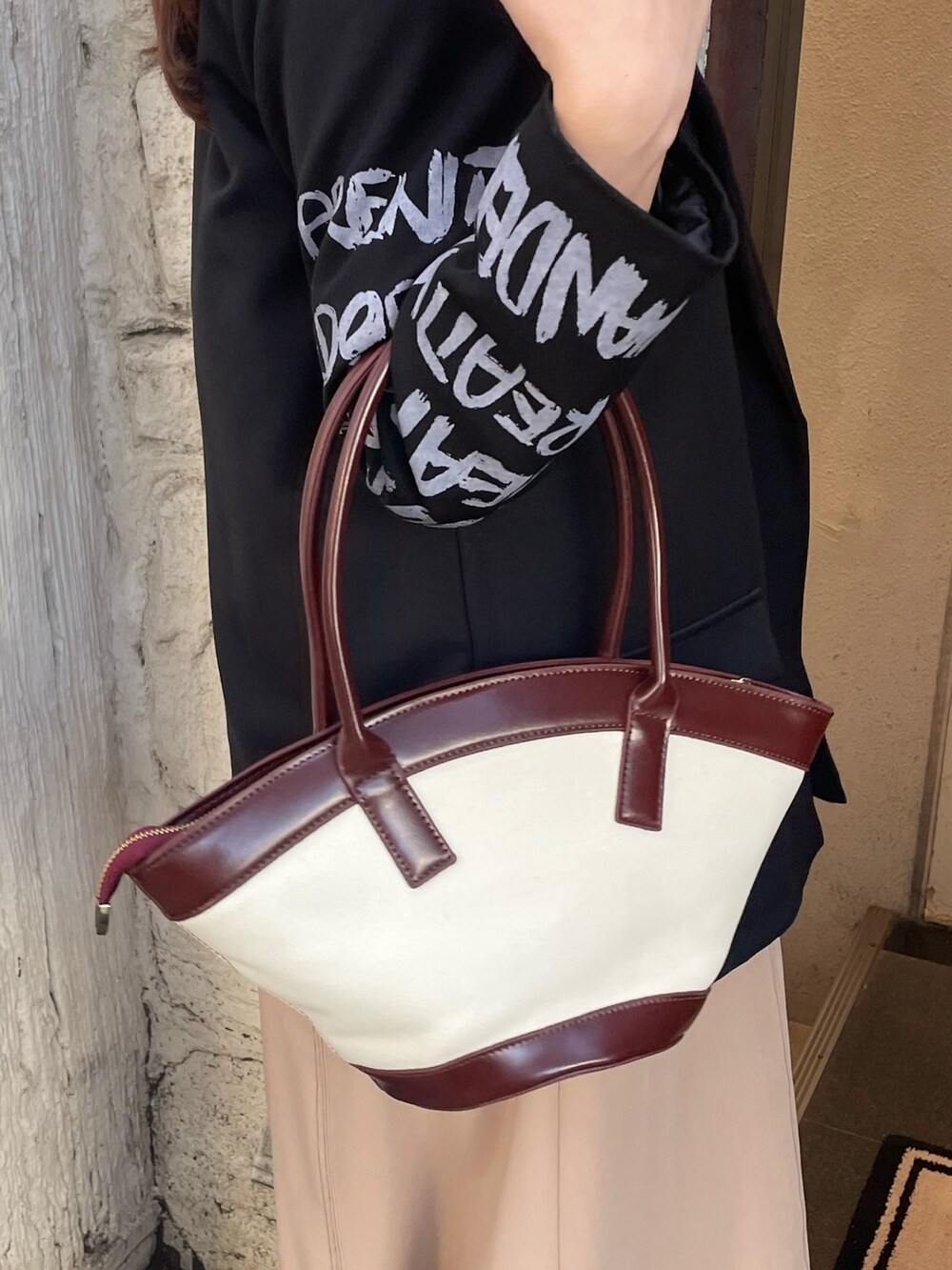 ベージュ系のワンピース、ブラウン系のハンドバッグ、ブラック系のサングラスを着用したレディースの秋コーディネートの4枚目の写真