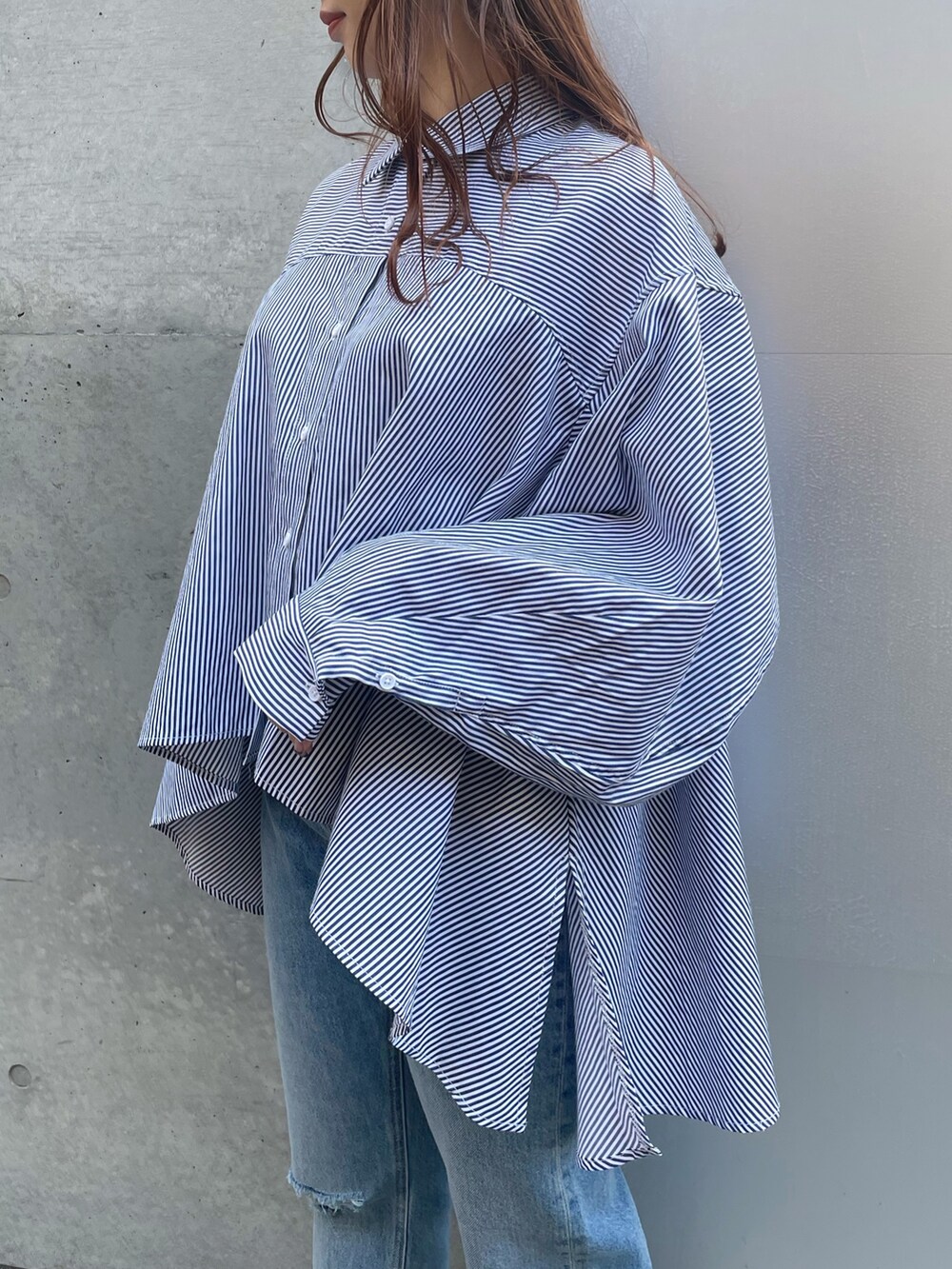 ブルー系のデニムパンツ、ブラック系のローファー、ブラック系のベストを着用したレディースの春コーディネートの8枚目の写真