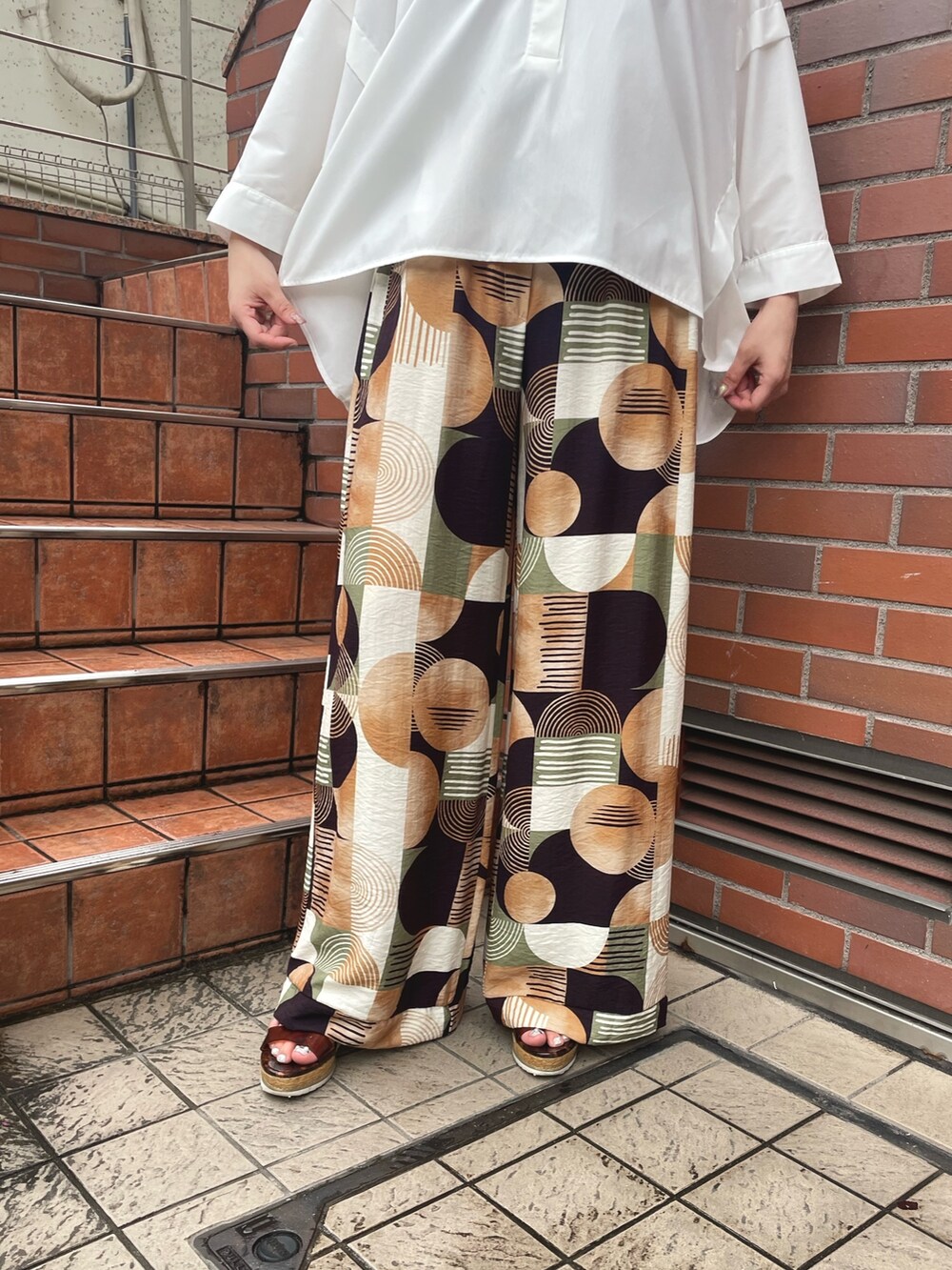 ブラウン系のその他パンツ、ホワイト系のシャツ/ブラウス、ブラック系のサングラスを着用したレディースの春コーディネートの5枚目の写真